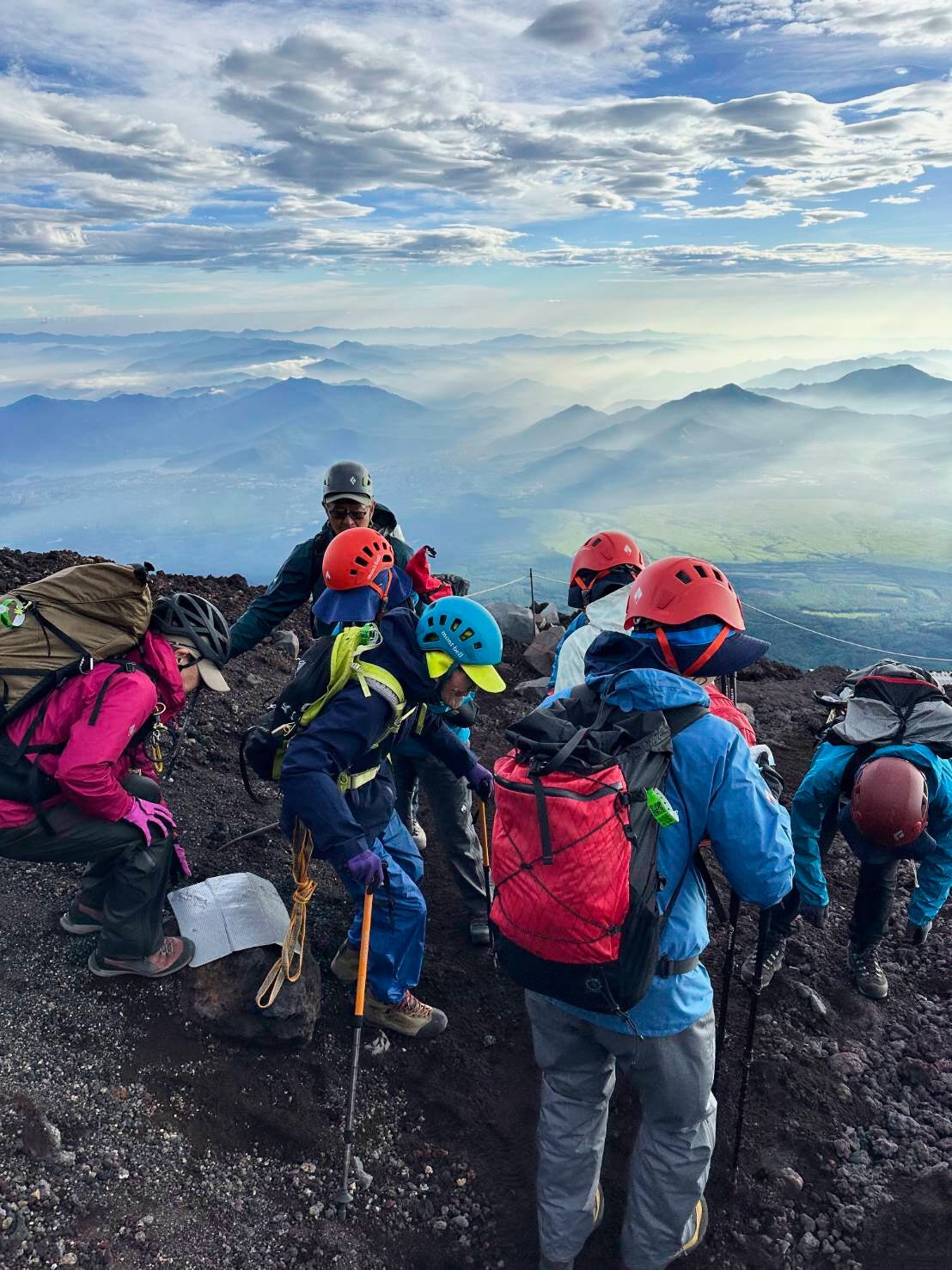 This photo provided by Motoe Hoshino shows her father Kokichi Akuzawa, center in a blue helmet, as they and their climbing friends and other family members were climbing Mount Fuji, west of Tokyo, Aug. 5, 2025. (Family courtesy photo via AP)