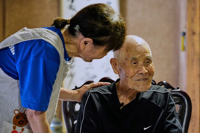 <p>Yukiko Akuzawa, left, helps repeat a journalist's question with a bit louder voice by her father Kokichi Akuzawa, who was recently recognized by Guinness World Records as the oldest person to climb Mount Fuji (male), during an interview with The Associated Press in Maebashi, northeast of Tokyo, Wednesday, Sept. 3, 2025. (AP Photo/Hiro Komae)</p>
