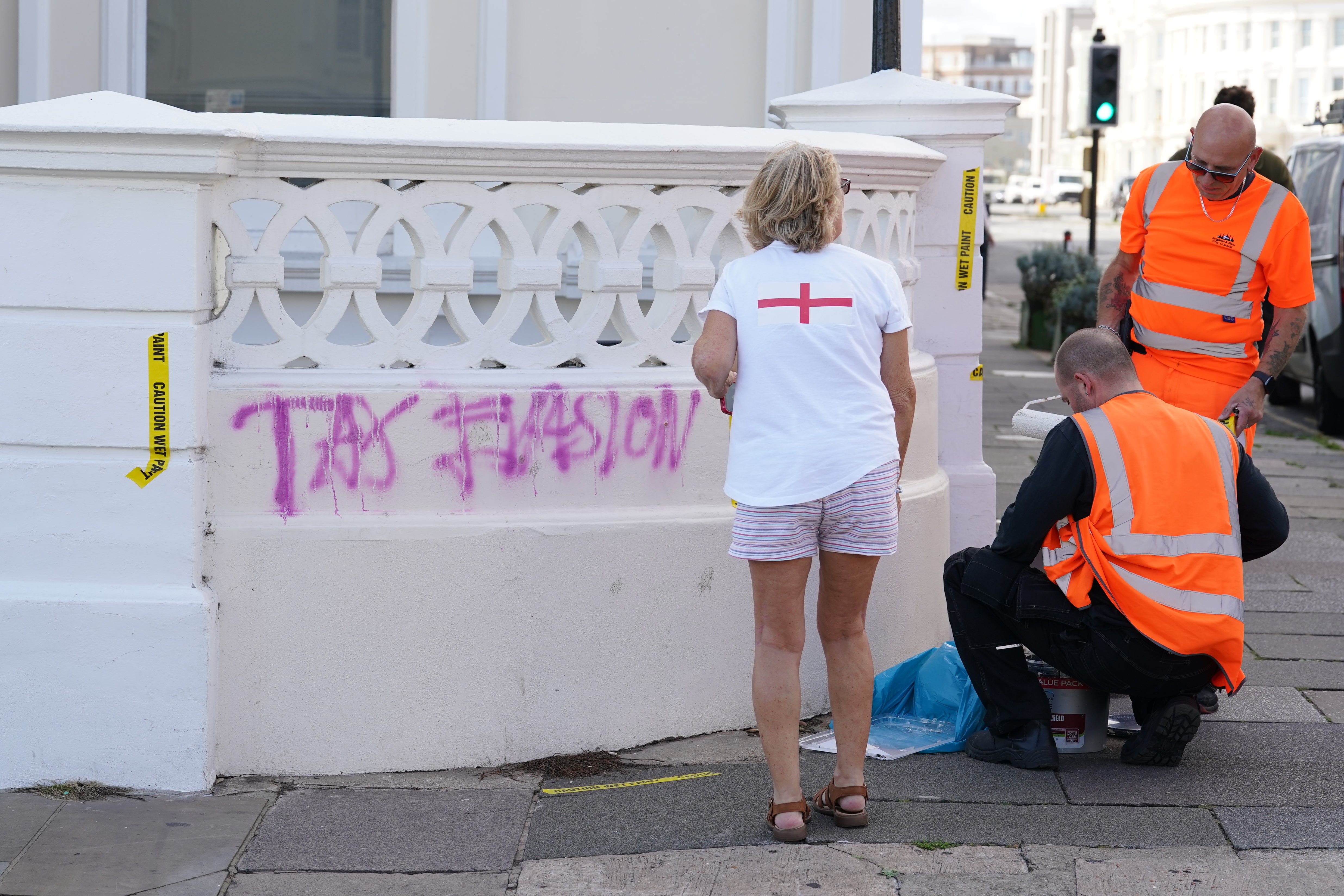 Workers prepare to paint over graffiti daubed outside the apartment building in Hove, East Sussex, where Angela Rayner owns a second home
