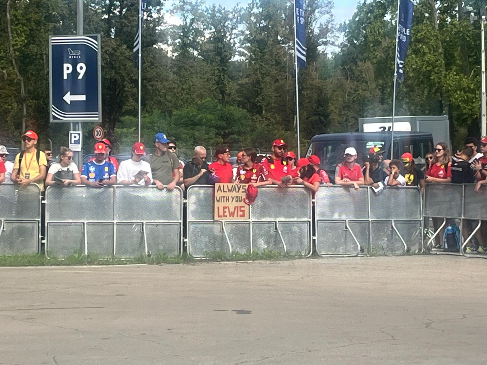 A fan holds an 'Always with you Lewis' poster at the entrance to the Monza circuit