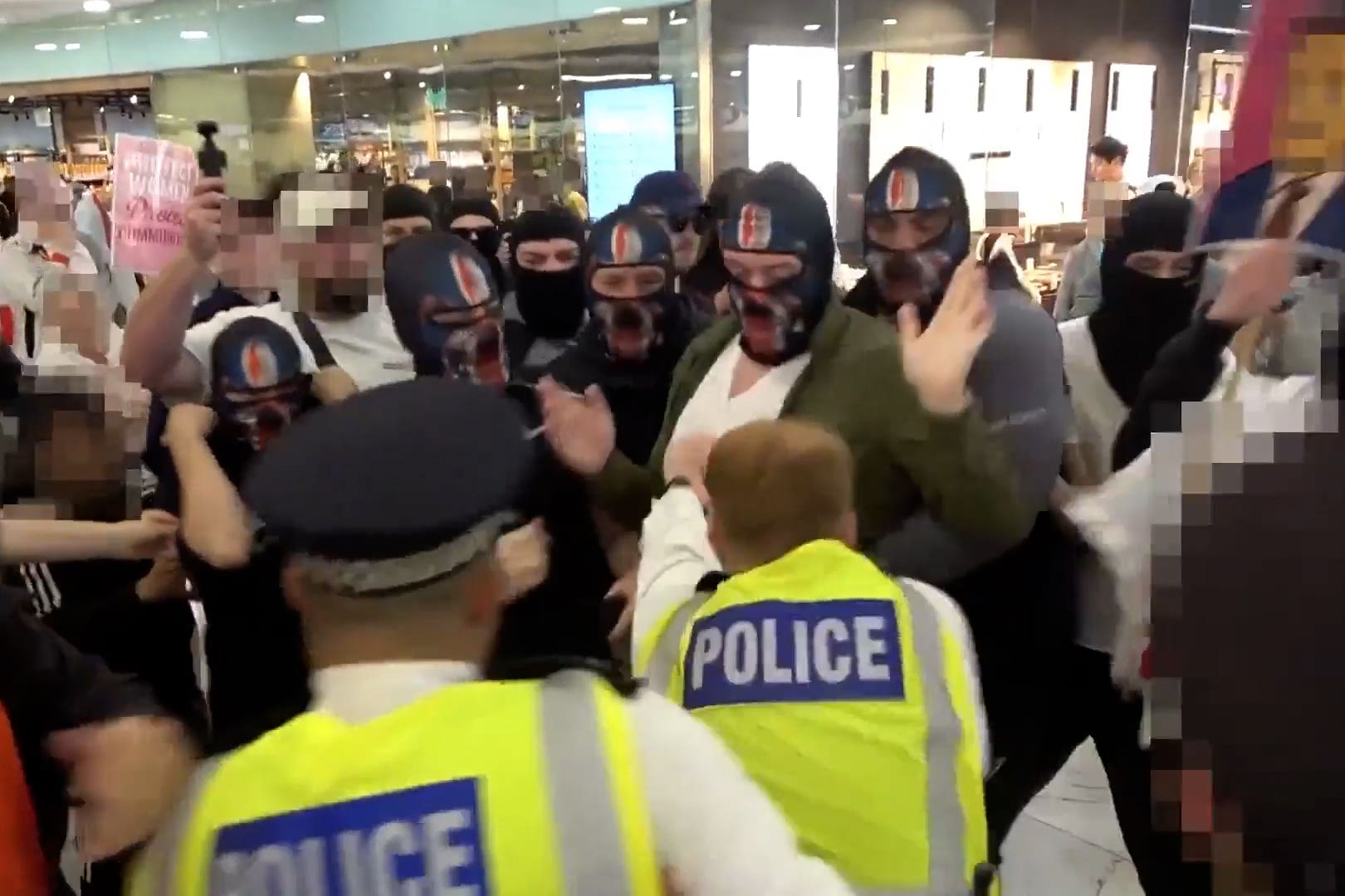 Video grab image issued by the Metropolitan Police of a clash between masked demonstrators and officers during an anti-illegal immigration protest in a Canary Wharf shopping centre (Metropolitan Police/PA)