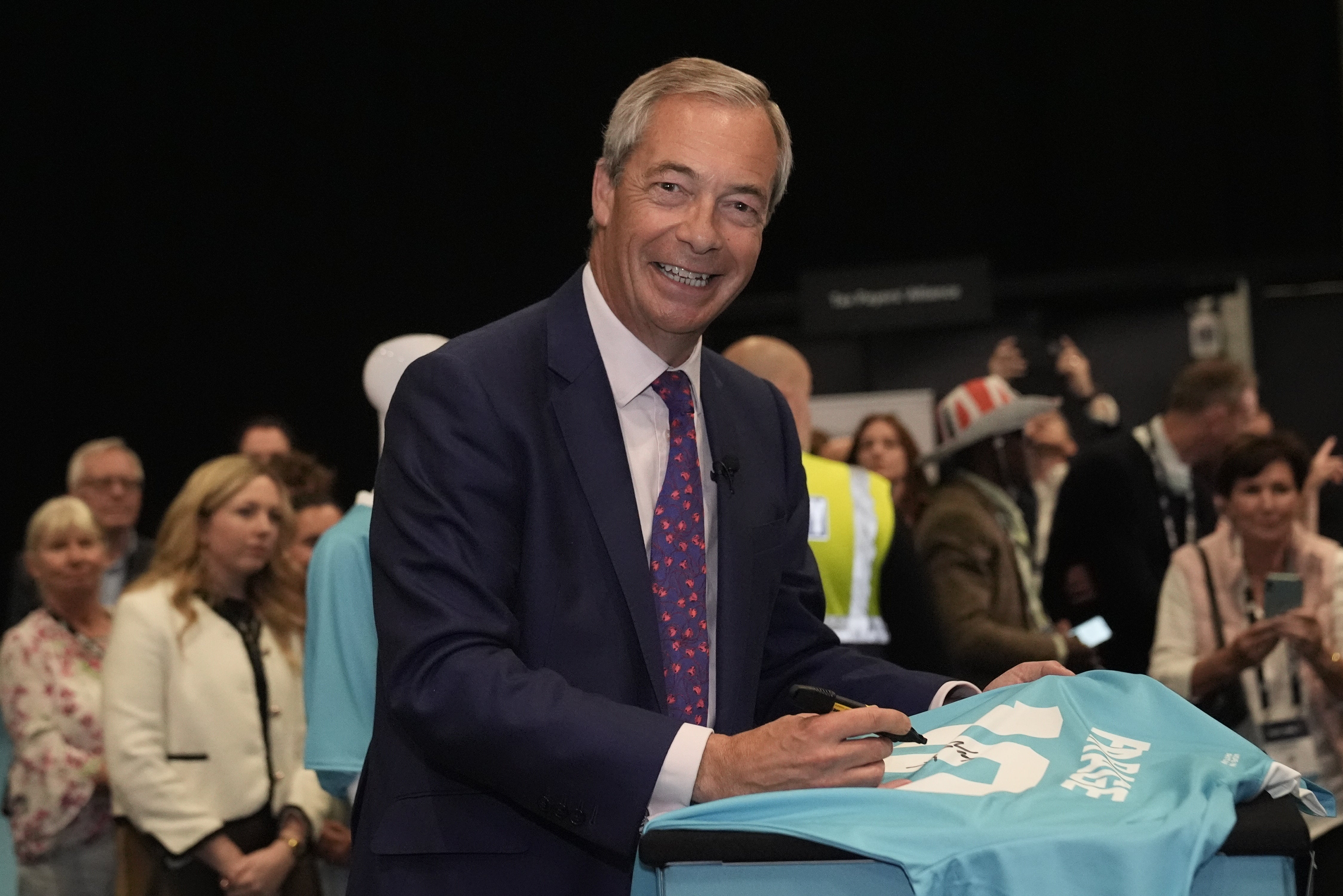 Farage signing a football shirt during the party’s conference in Birmingham