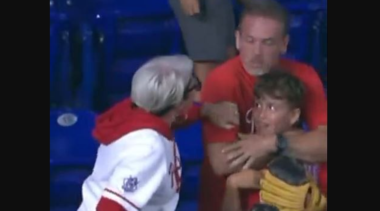 A woman at a Philadelphia Phillies game demands a home run ball from a father who grabbed it to give to his young son