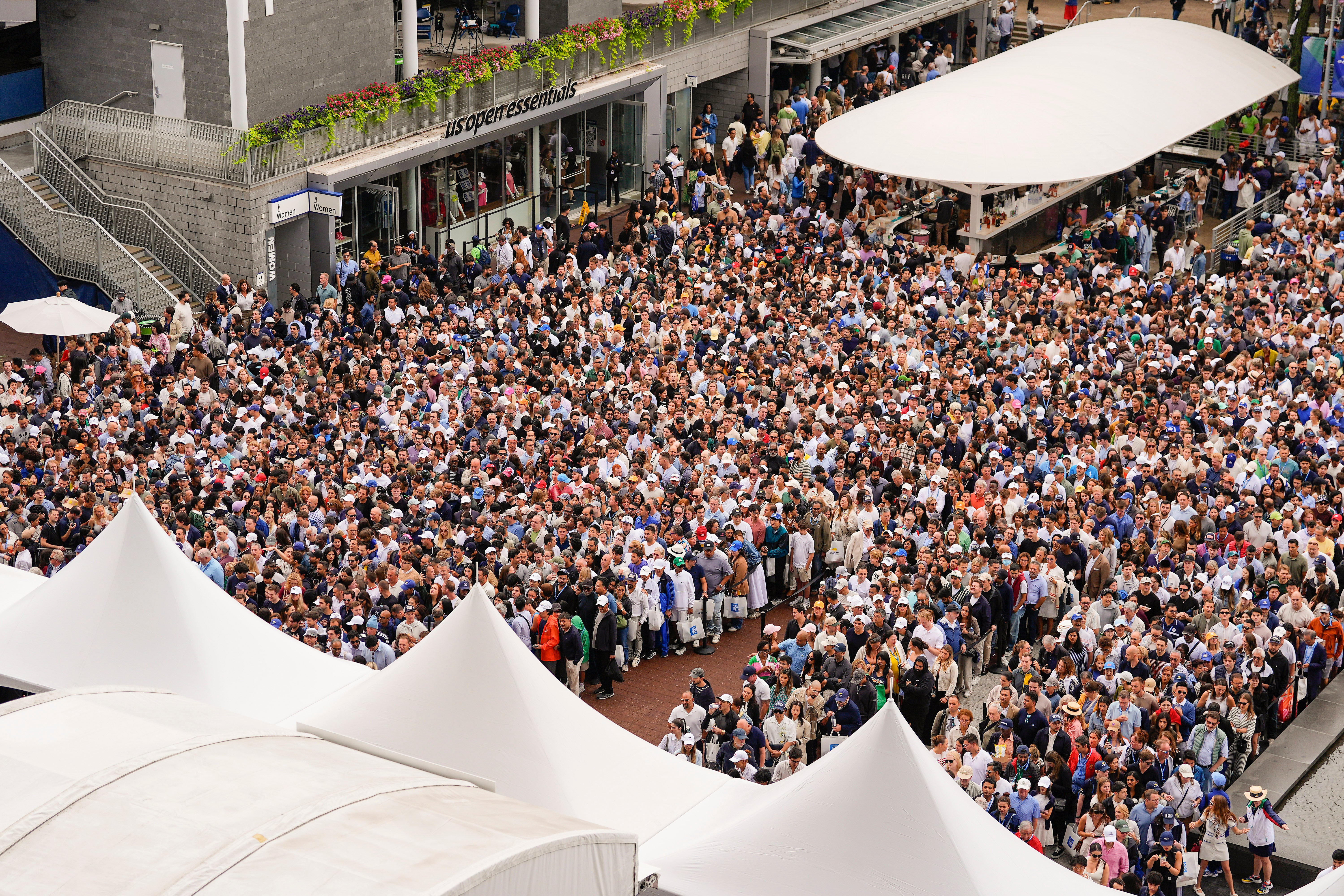 Tenisoví fanoušci se vstupují, aby se dostali na stadion Arthur Ashe, aby sledovali Jannik Sinner z Itálie a Carlos Alcaraz ze Španělska, hrají ve finále mužských singlů finále amerických otevřených tenisových mistrovství