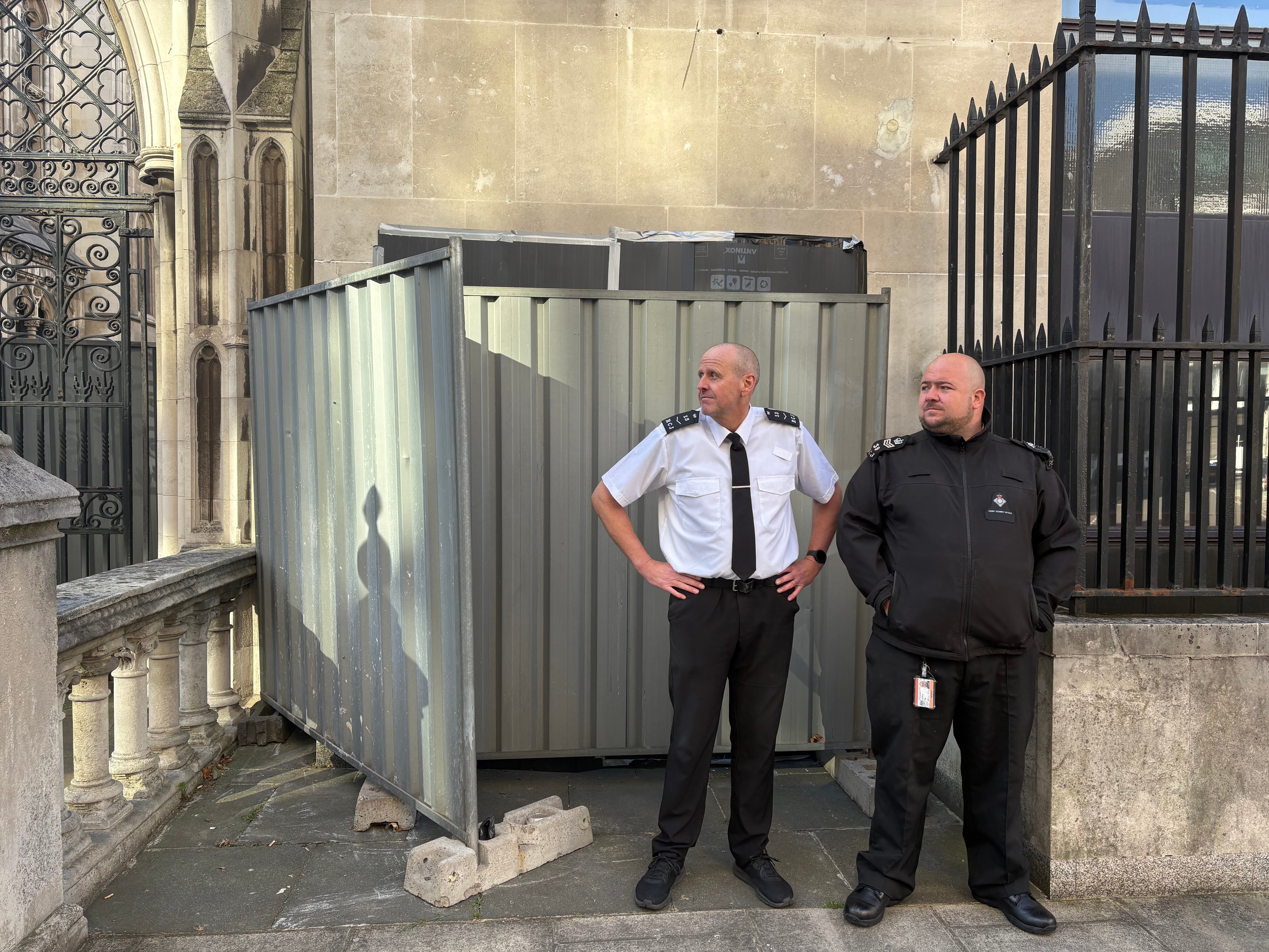 The new Banksy artwork is being guarded by security officials outside the building and sits underneath a CCTV camera.
