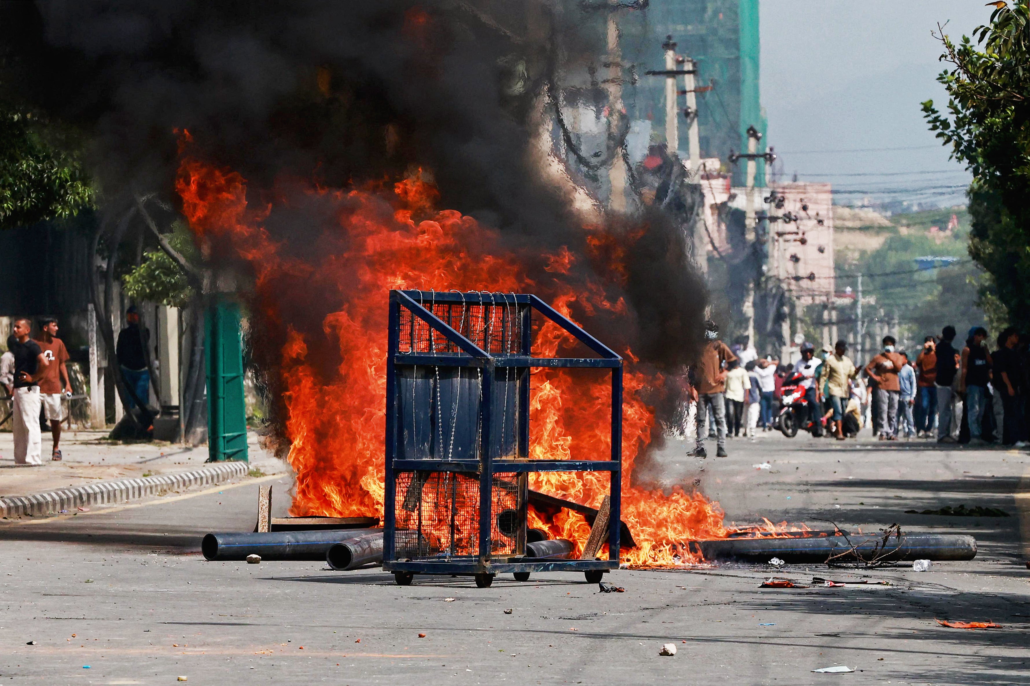 A police barricade in front of a fire set alight by demonstrators