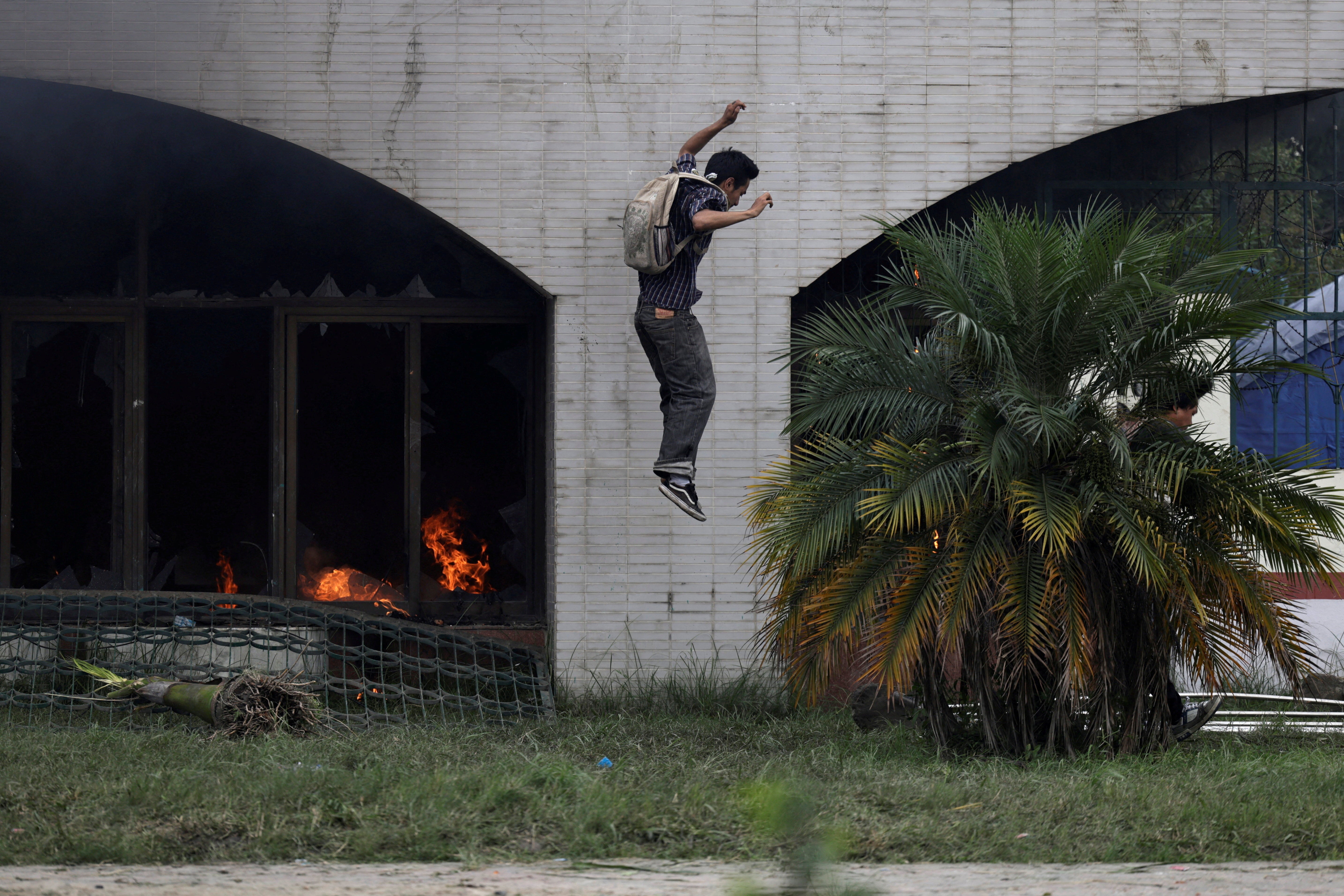 A demonstrator jumps from the gate of the Parliament building in Kathmandu