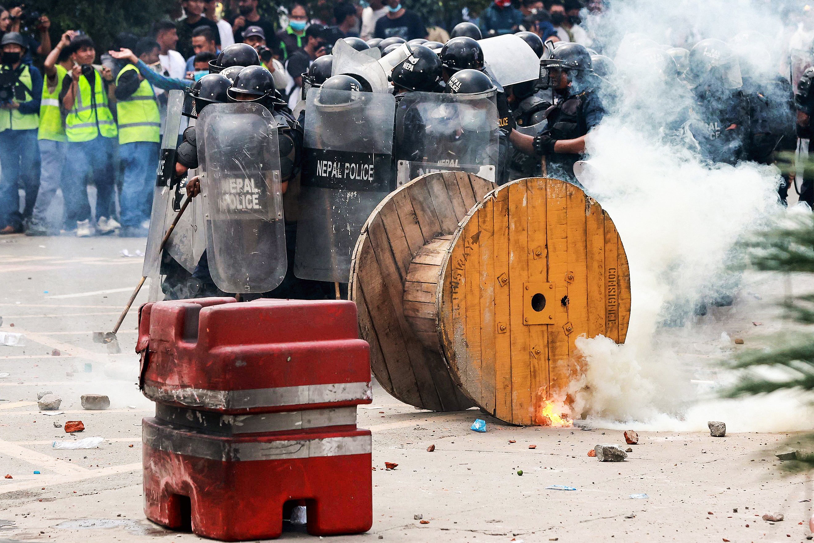 Riot police personnel fire tear gas as demonstrators pelt stones during a protest outside the Parliament in Kathmandu on 8 September 2025