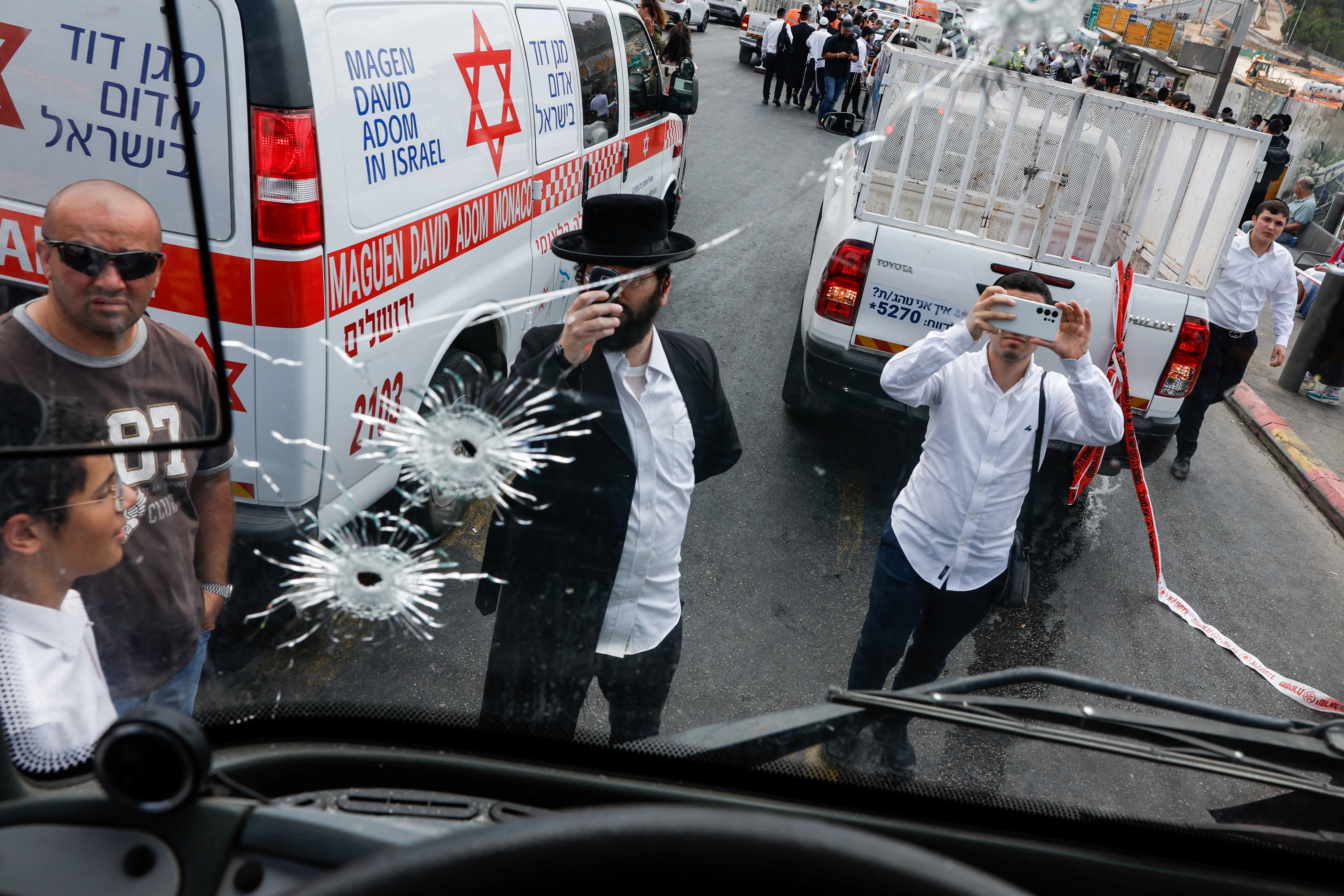 People inspect a bus with bullet holes at the scene where a suspected shooting attack took place at the outskirts of Jerusalem, September 8, 2025 REUTERS/Ammar Awad