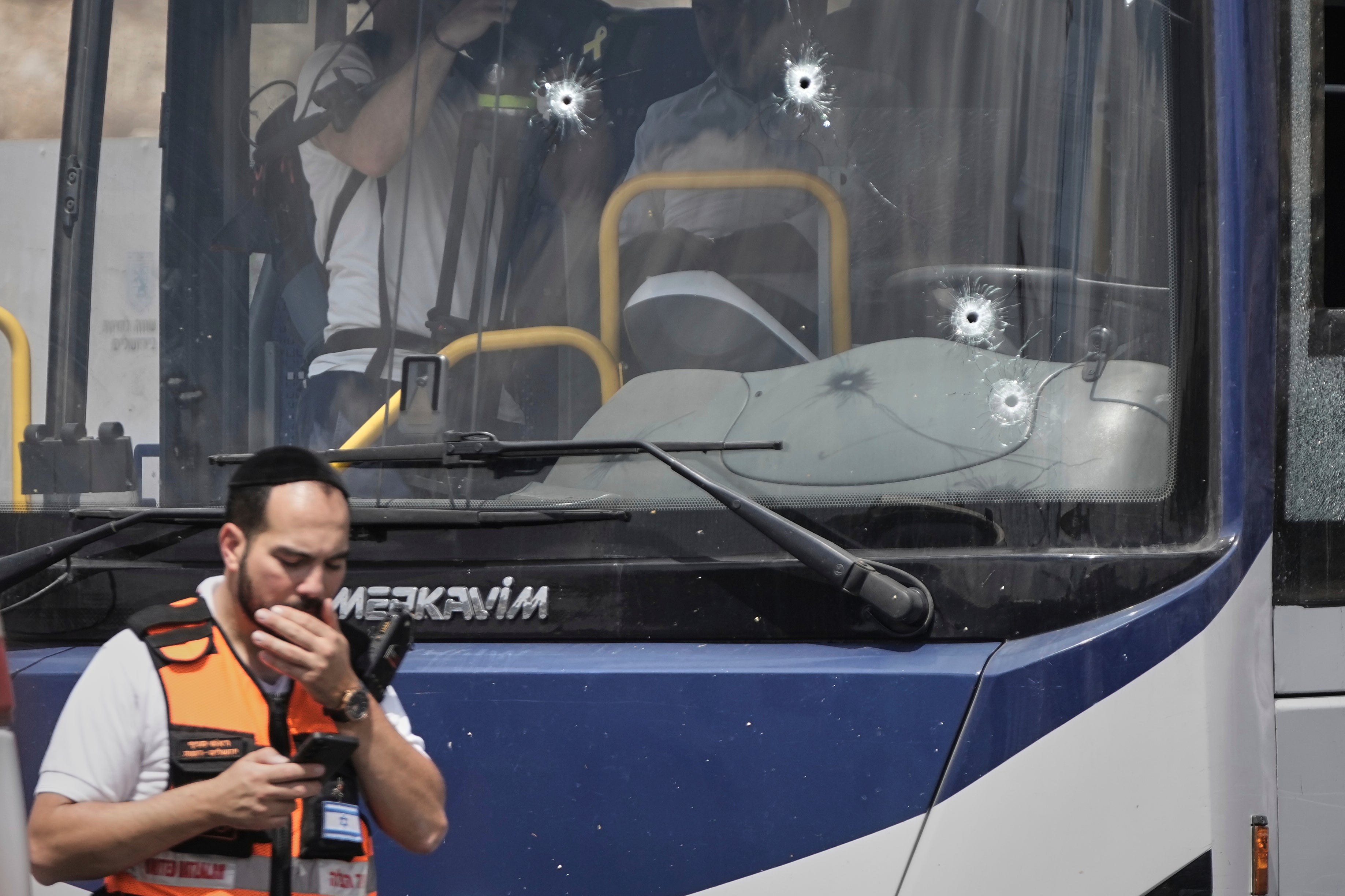 Israeli police and rescue teams inspect the scene of a shooting attack carried out by two Palestinian gunmen, in which several people were killed and others injured at a bus stop in Jerusalem, Monday 8 September
