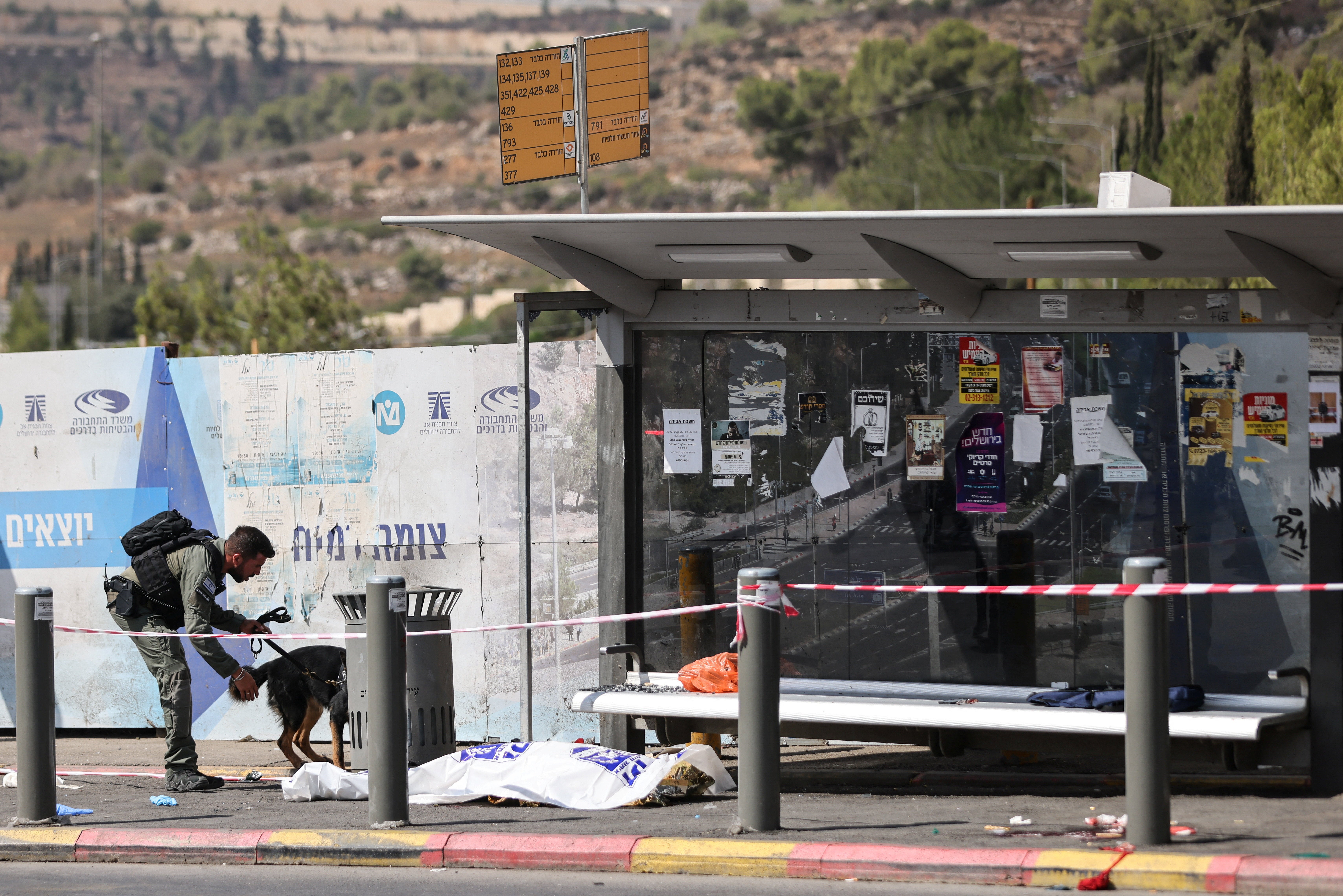 A security officer and his dog work at the scene of the shooting on the outskirts of Jerusalem