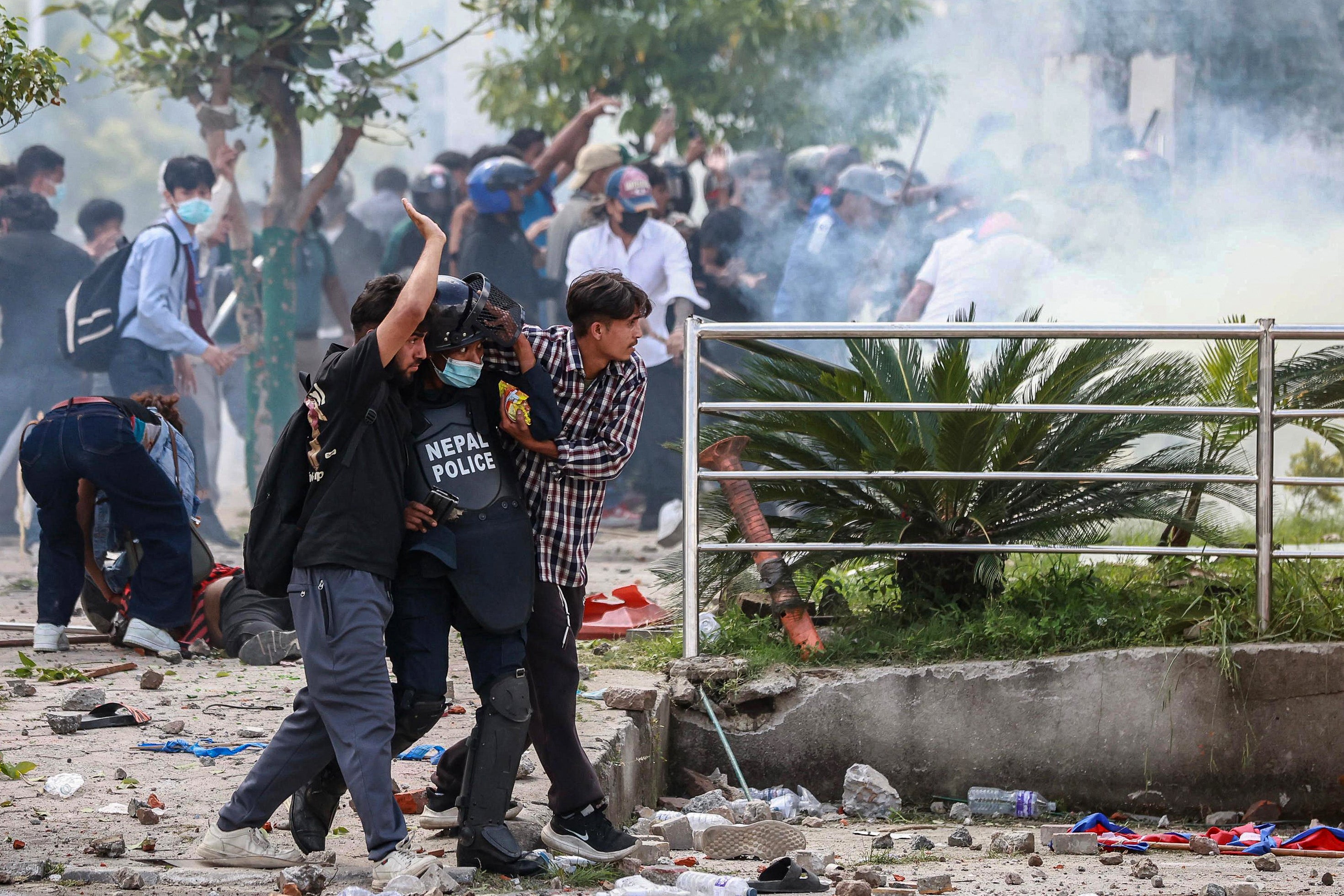 Demonstrators carry an injured police officer