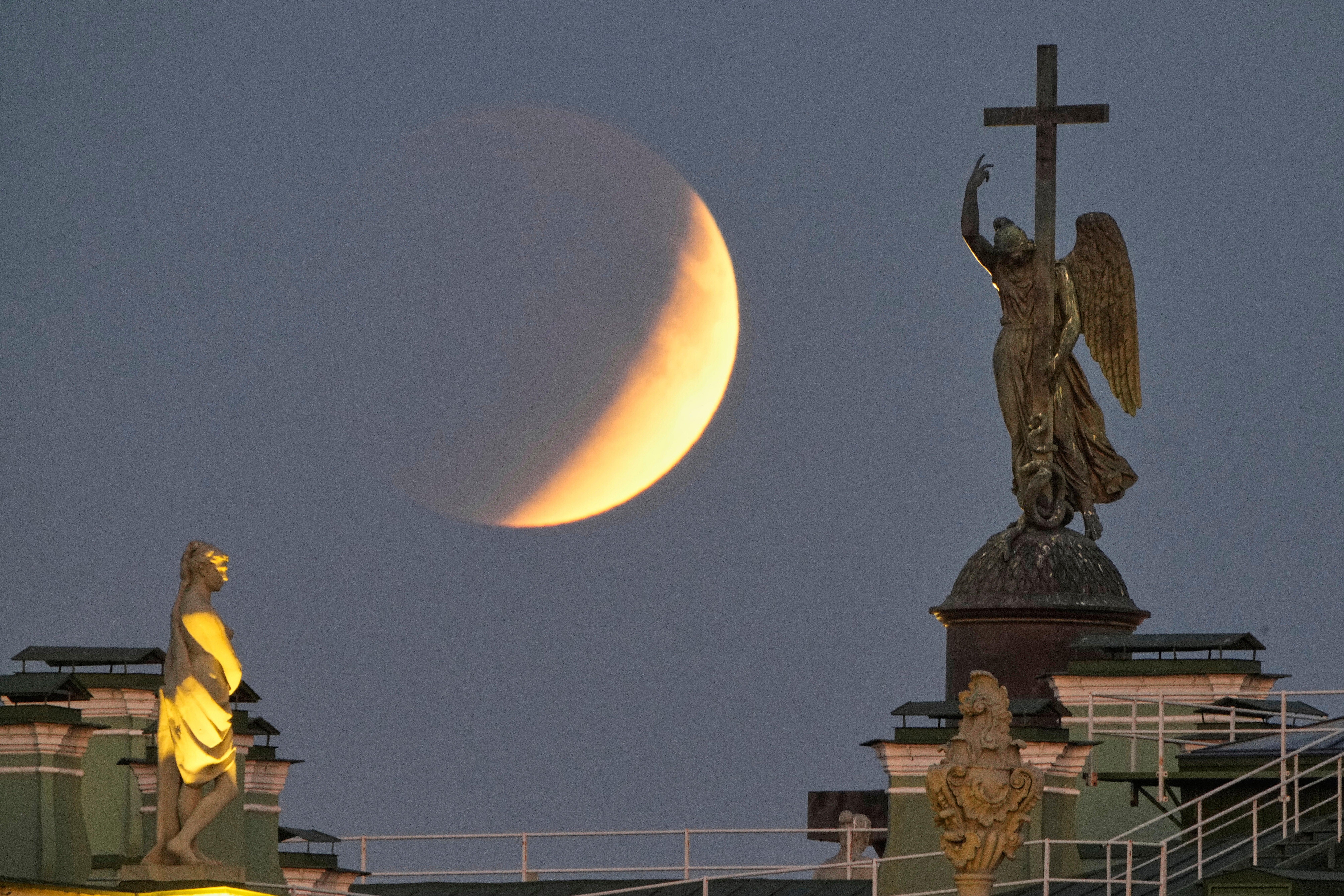 The full moon rises behind a statue of an angel fixed atop the Alexander Column at the Palace Square for a total lunar eclipse in St Petersburg, Russia, Sunday, 7 September 2025