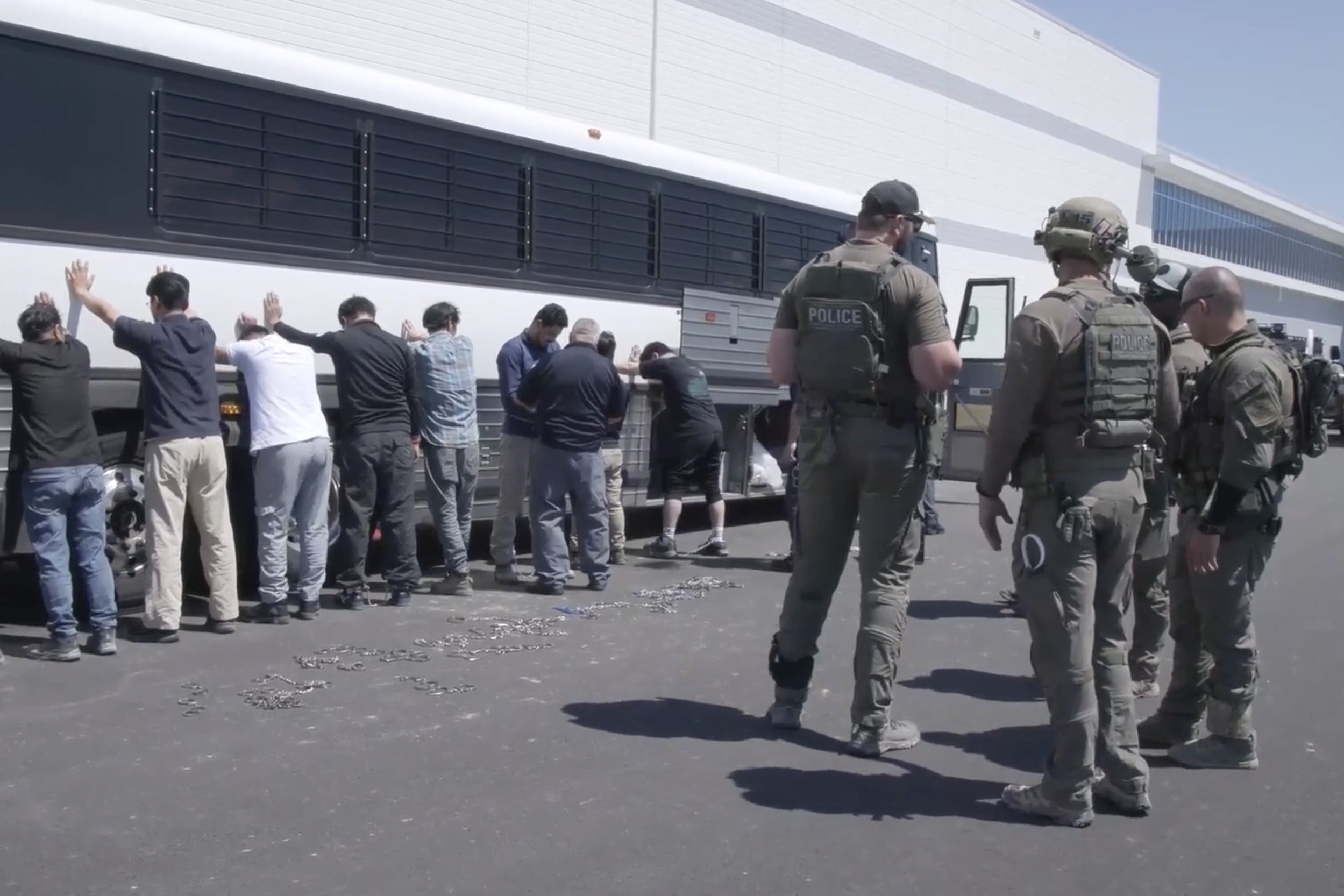 Manufacturing plant employees waiting to have their legs shackled at the Hyundai Motor Group's electric vehicle plant. Hyundai CEO José Muñoz said production at the plant would likely be delayed by months due to the ICE raid