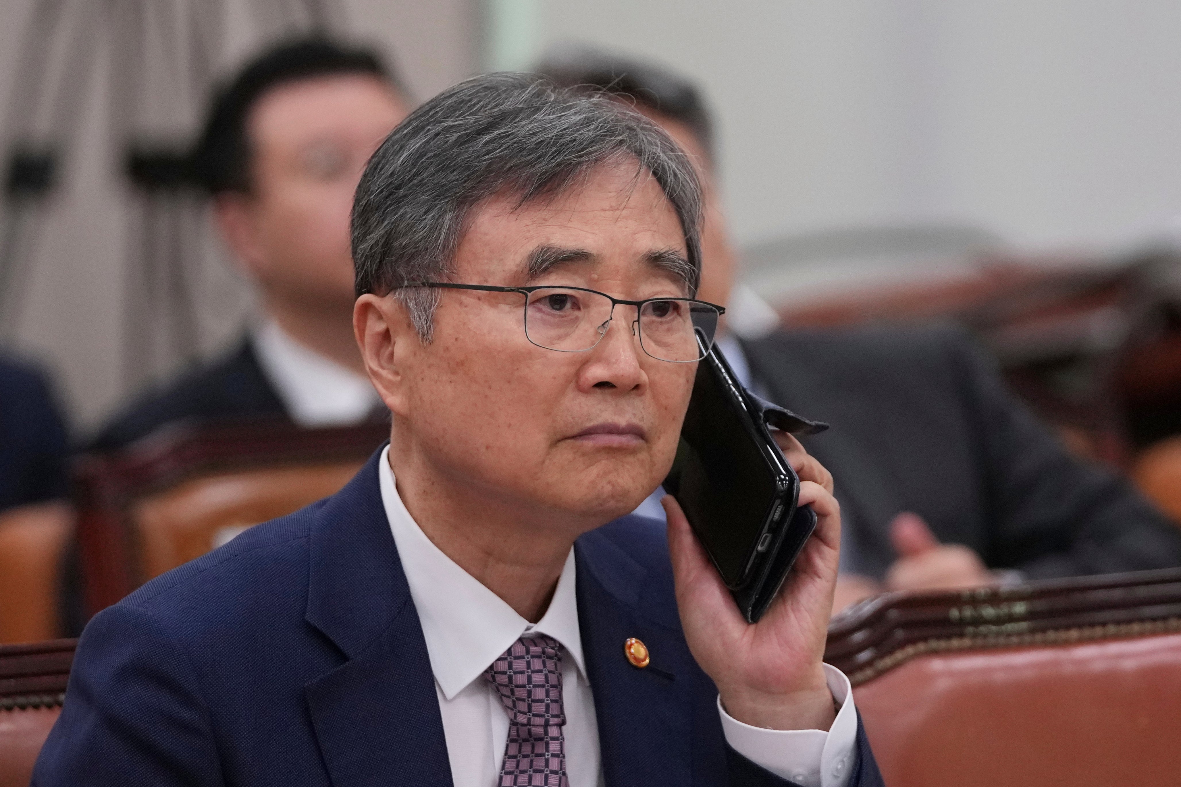 South Korean foreign minister Cho Hyun holds his mobile phone before a session of the Foreign Affairs and Unification Committee at the National Assembly in Seoul