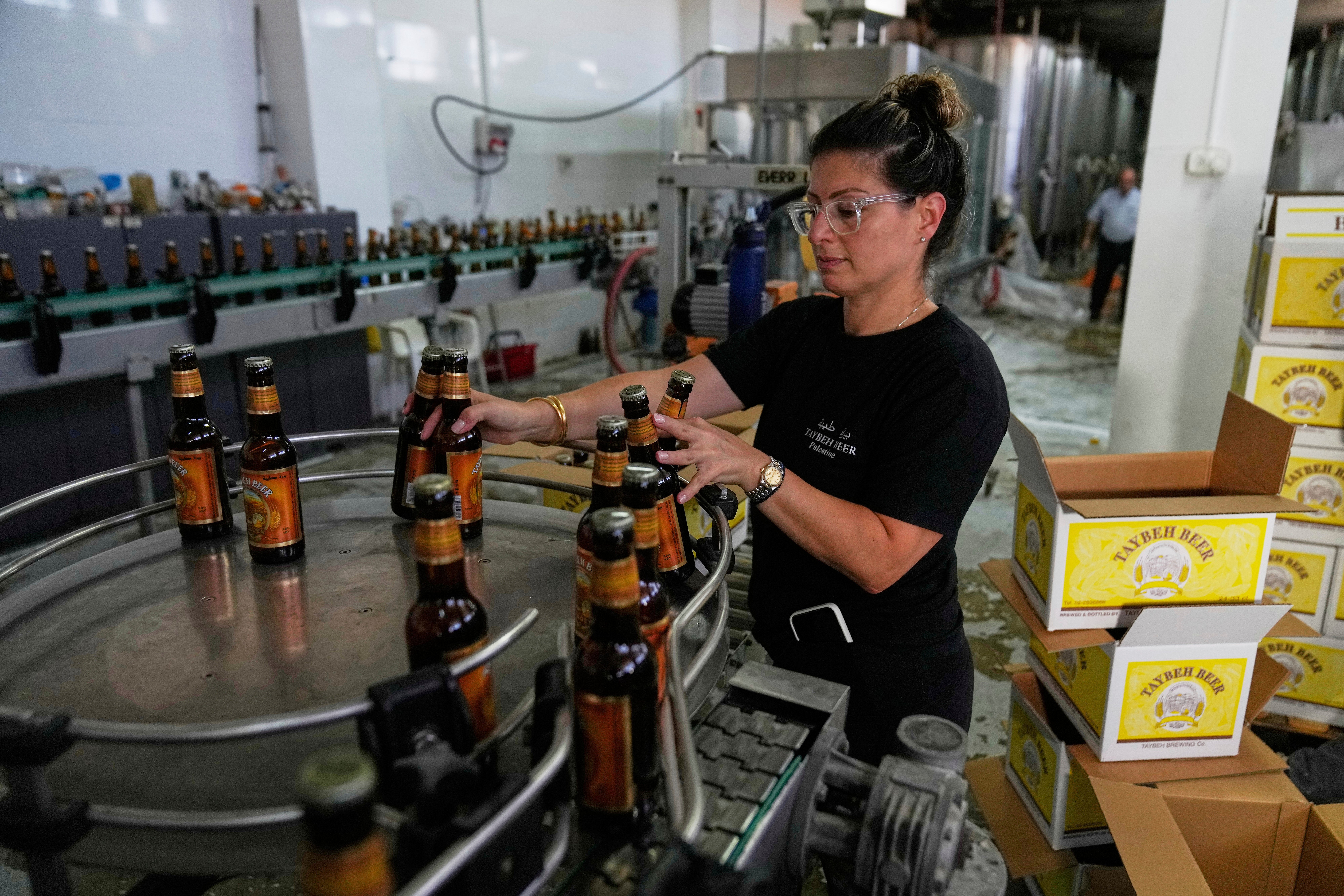 Nadin Khoury, 36, packs Taybeh beer products on a production line