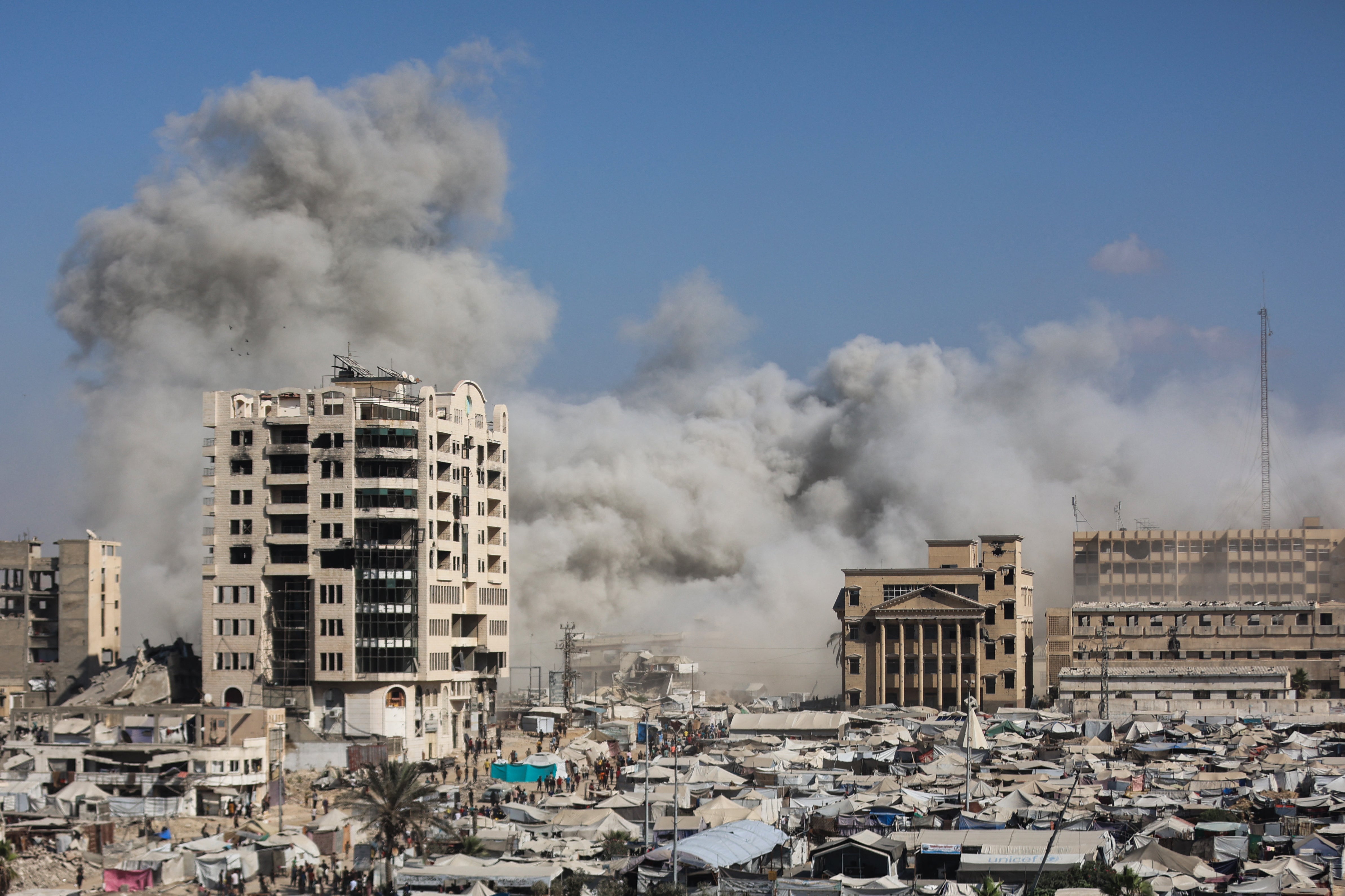 Smoke billows near tents sheltering displaced Palestinians after Israeli bombardment of Al-Ruya Tower in Gaza City