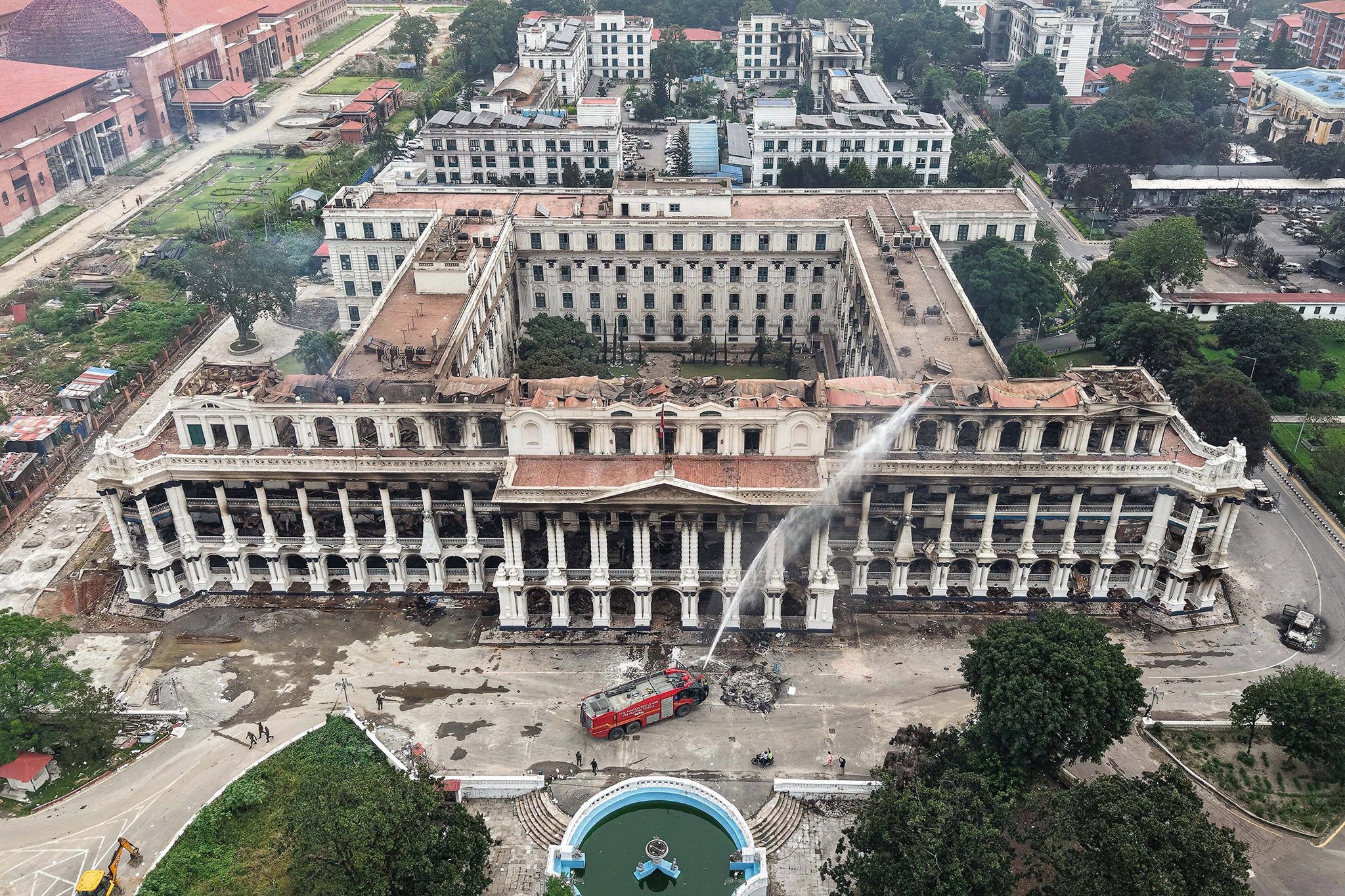 Firefighters dousing the torched government complex a day after it was set ablaze