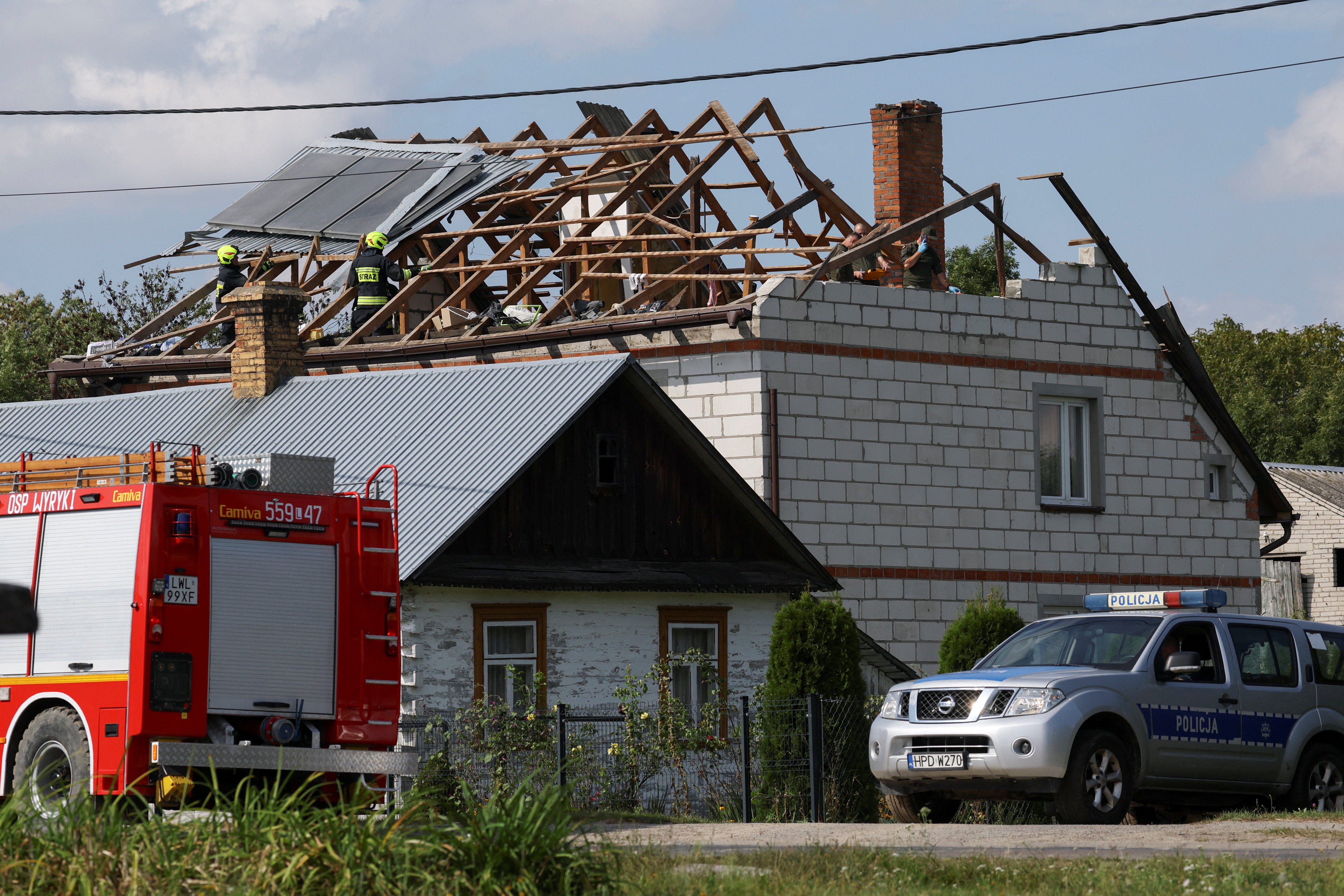 Firefighters work on the destroyed roof of a house, after Russian drones violated Polish airspace during an attack on Ukraine