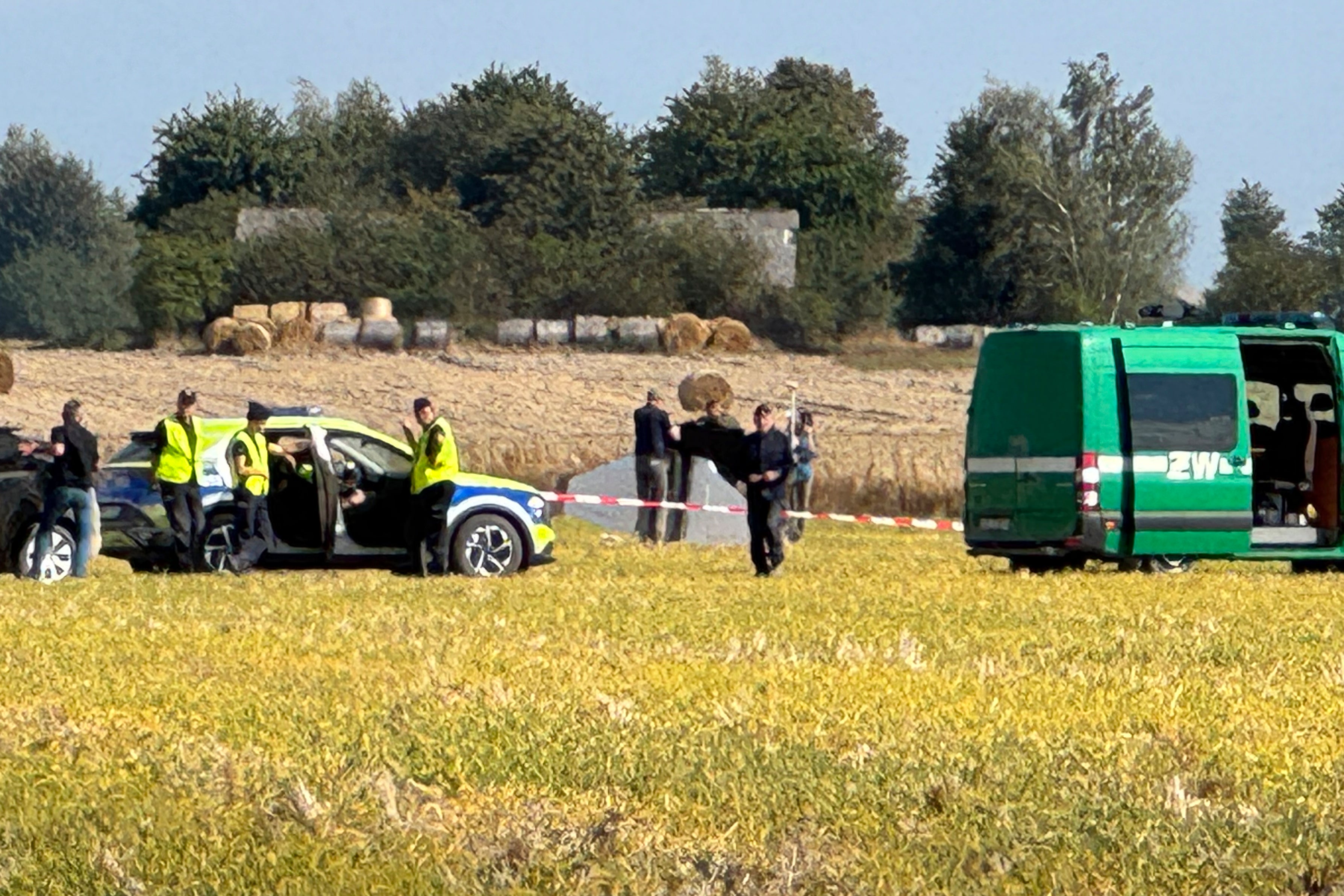 Polish police and military police secure parts of a damaged UAV shot down in Wohyn, Poland