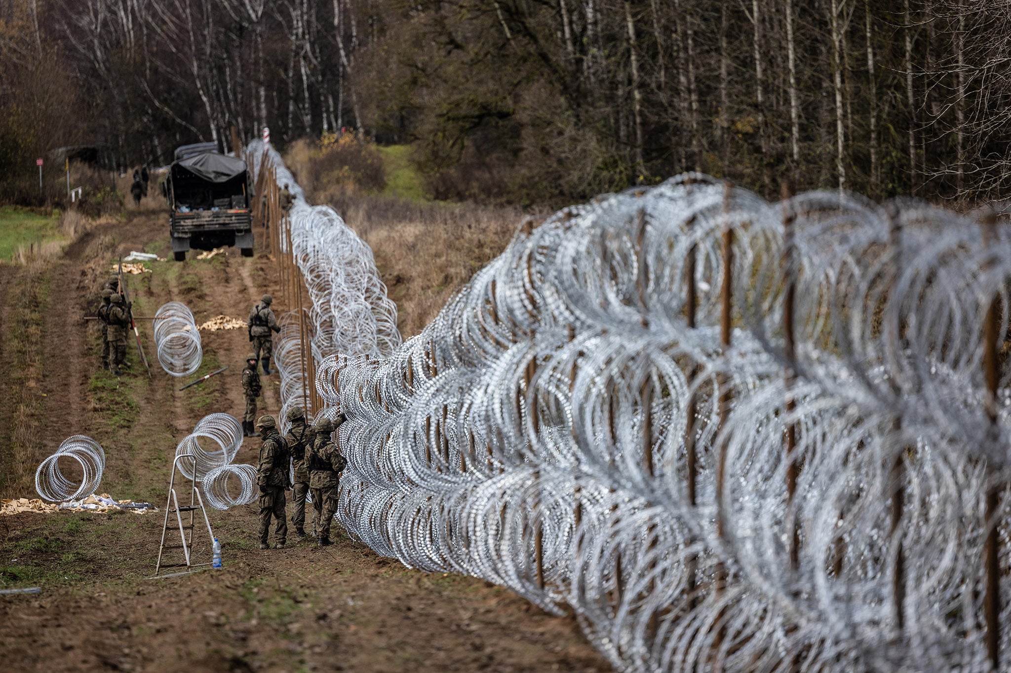 Polish soldiers build a wire fence on the Polish-Russian border in 2022