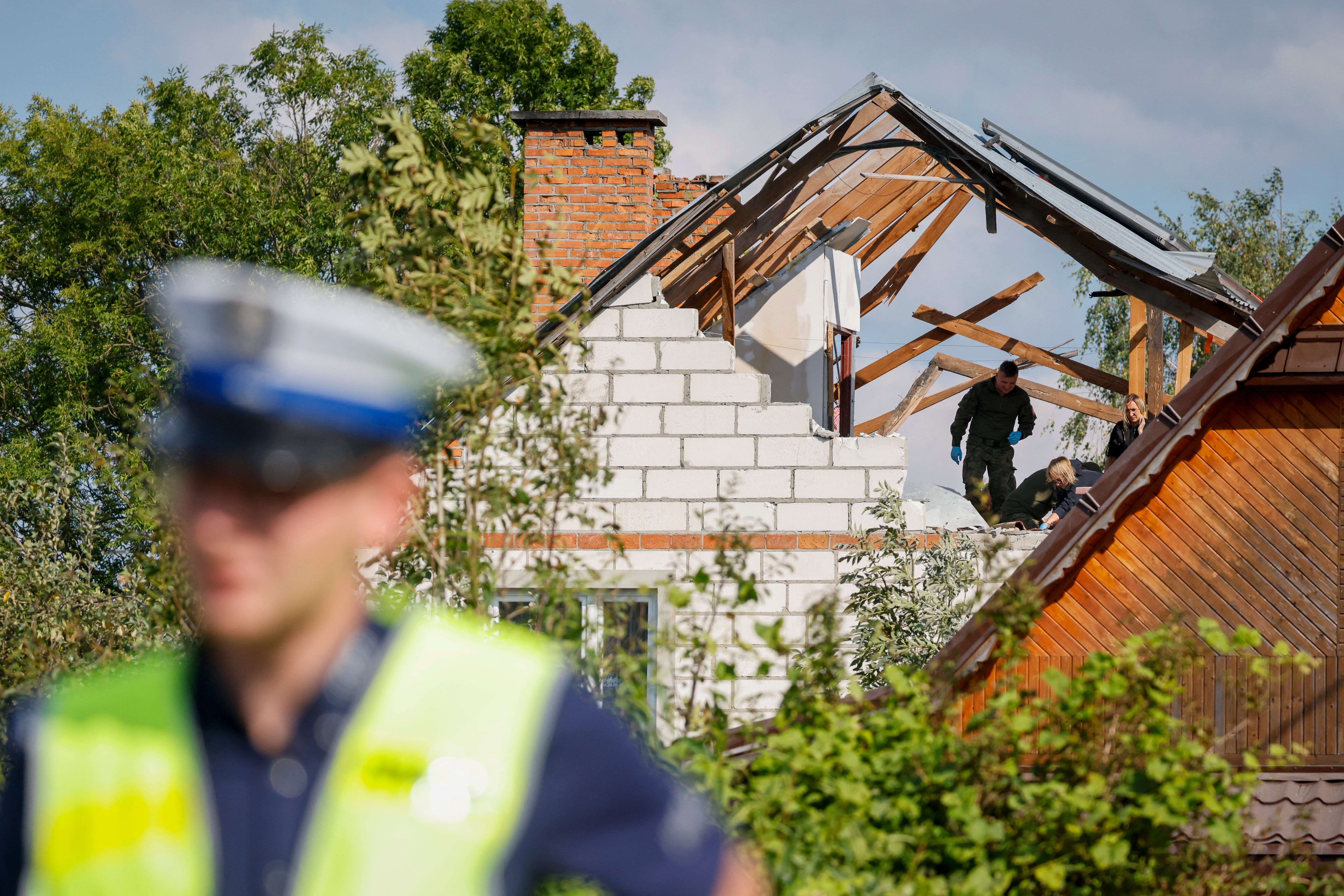 Police and army inspect damage to a house destroyed by debris from a shot down Russian drone in the village of Wyryki-Wola, eastern Poland, on September 10, 2025