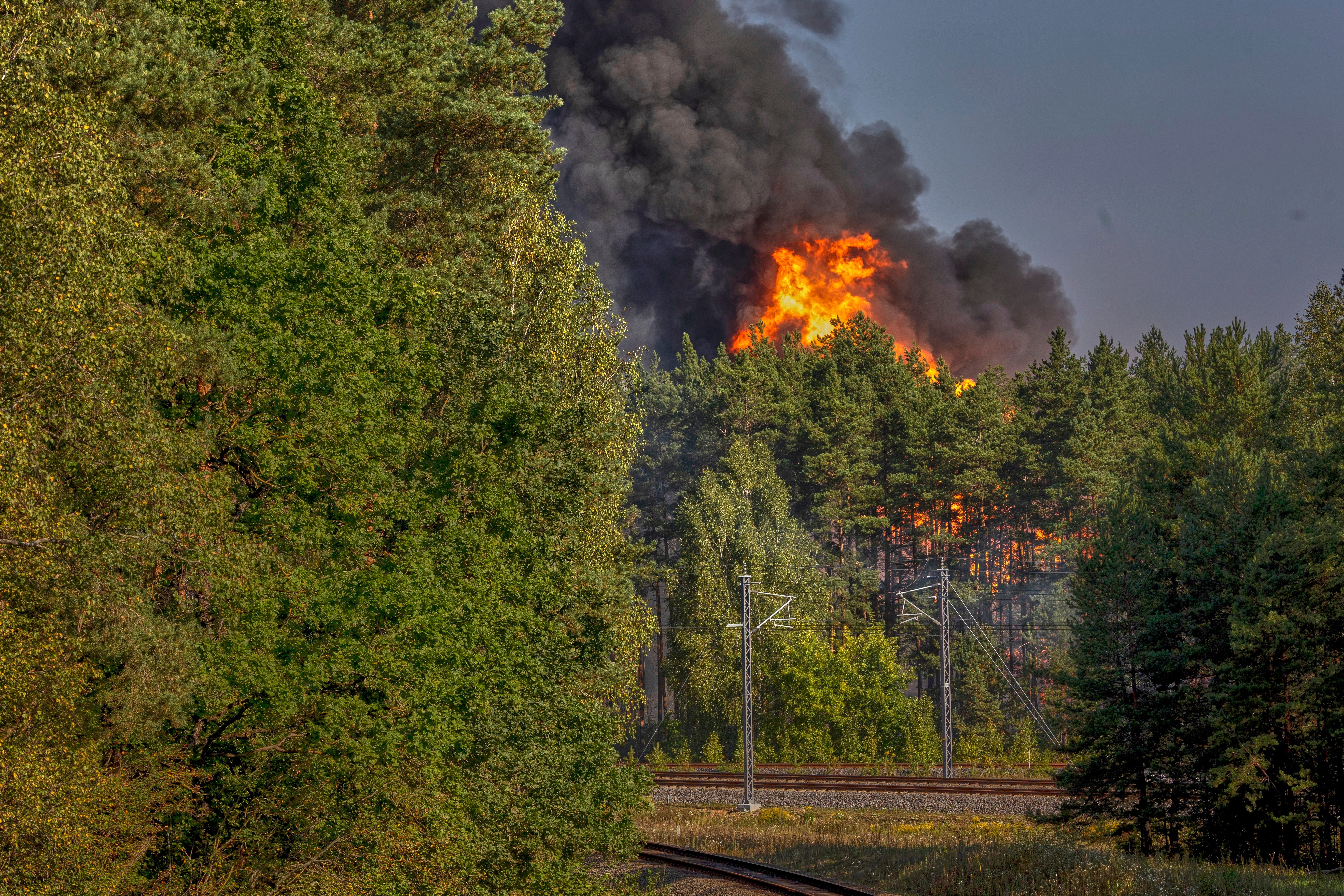 Smoke and flames rise following powerful explosions after several rail cars loaded with liquefied gas caught fire in the suburbs of Vilnius, Lithuania, Wednesday, Sept. 10, 2025. (AP Photo/Mindaugas Kulbis)