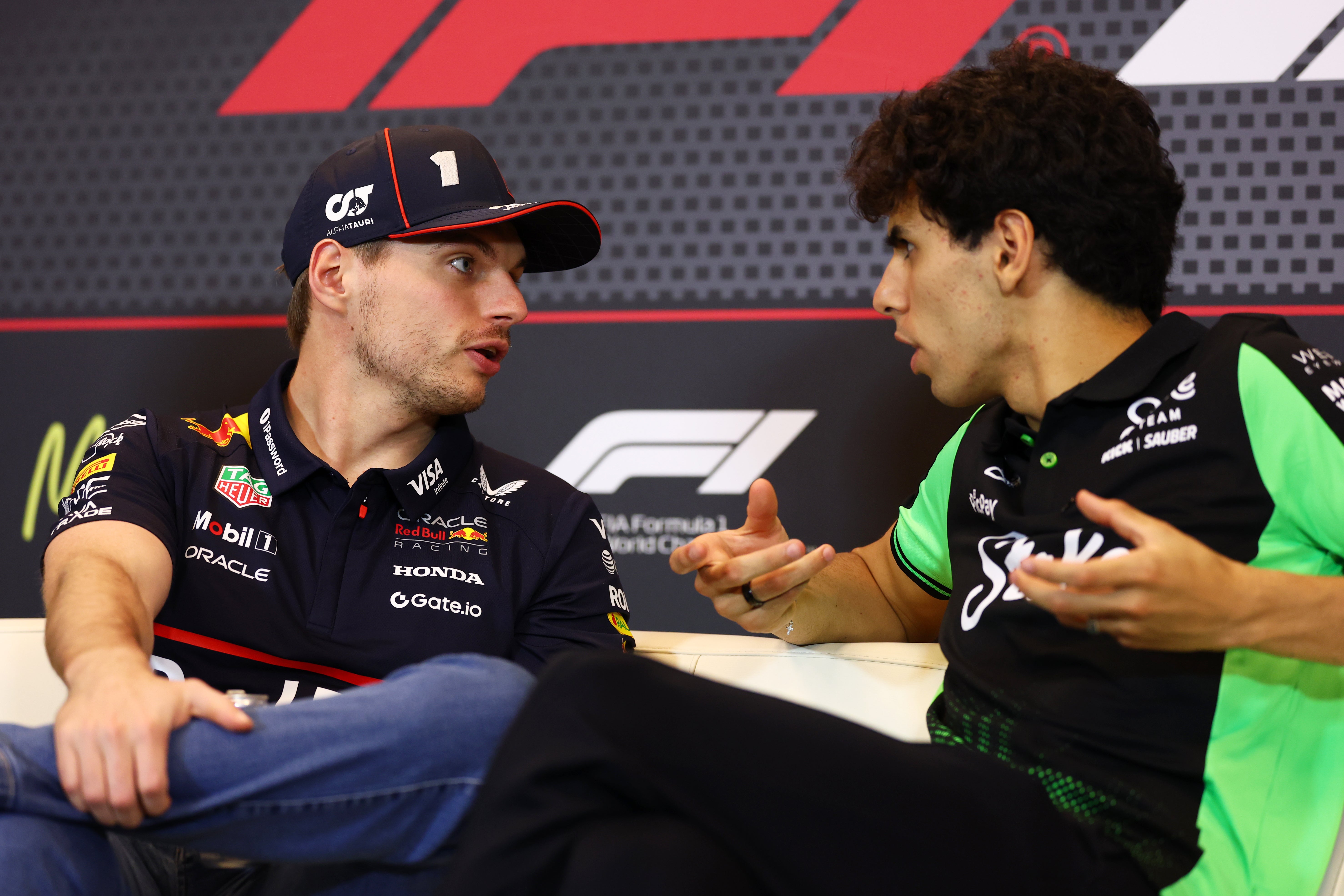 Bortoleto speaks to Max Verstappen at a press conference earlier this year