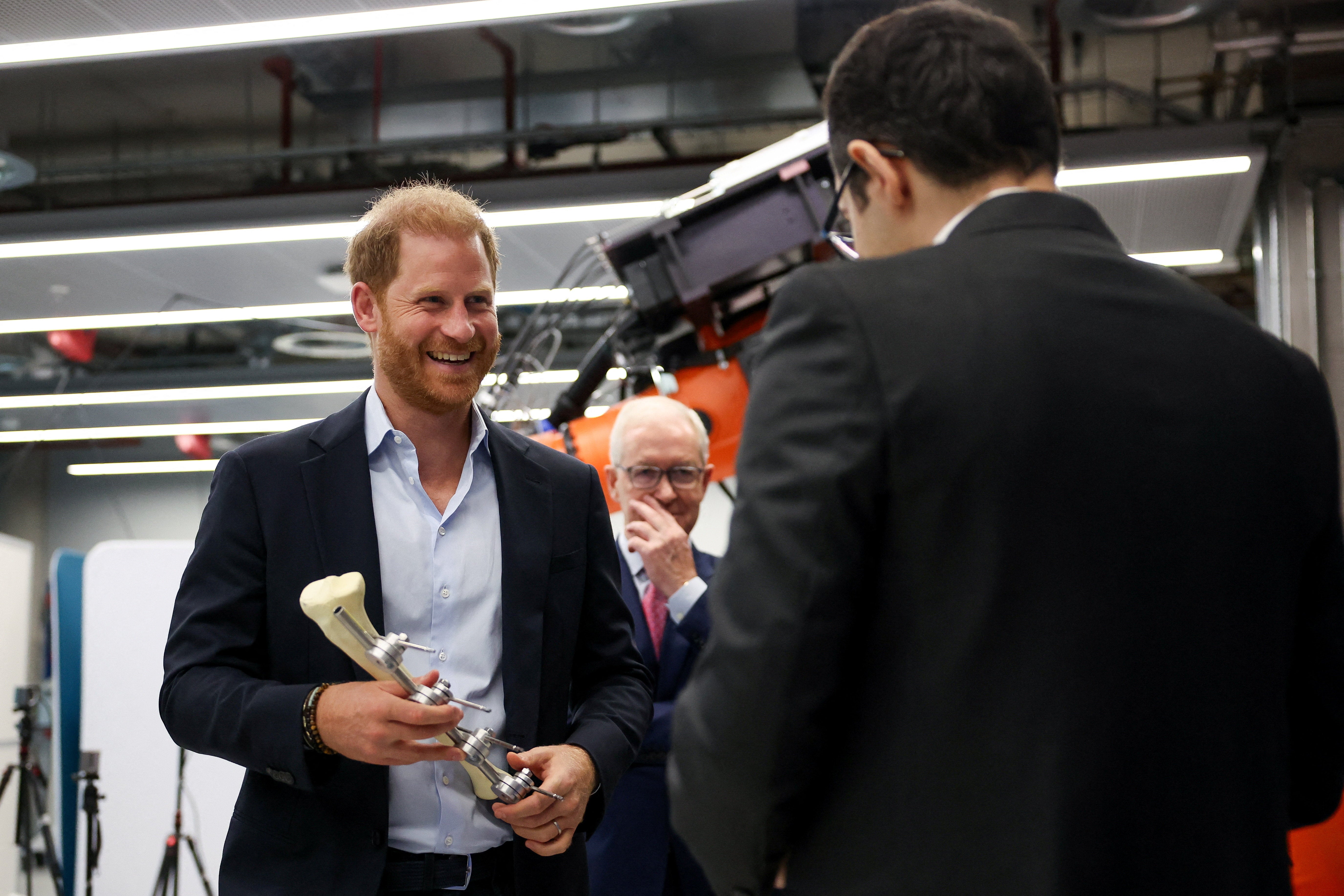 The Duke of Sussex holds an imperial external fixator during a visit to Imperial College London (Suzanne Plunkett/PA)