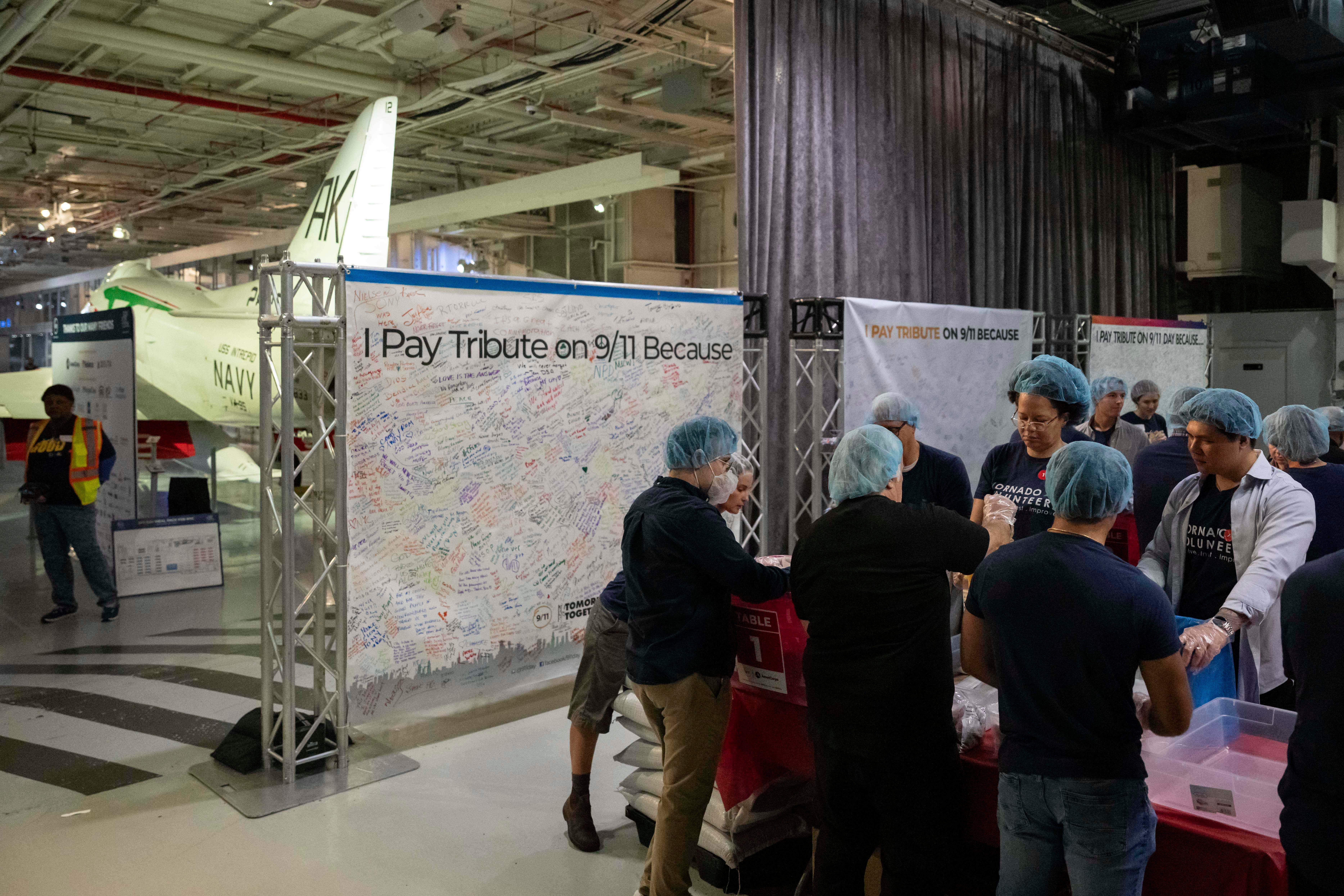 Volunteers work during the "NYC Meal Pack For 9/11 Day" at the Intrepid Sea, Air & Space Museum in New York