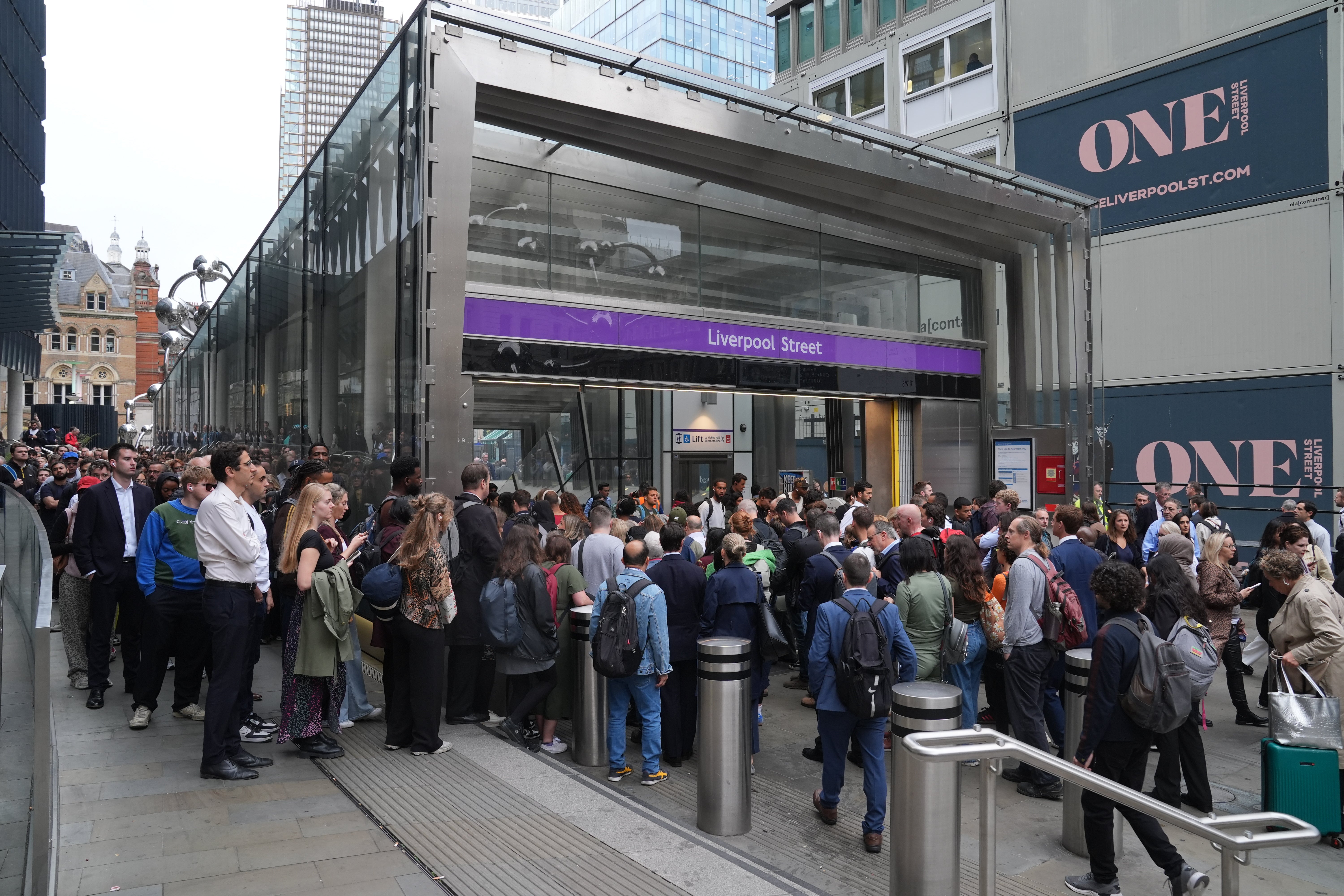 Passengers queue up outside Liverpool Street station as they try to get on an Elizabeth line train