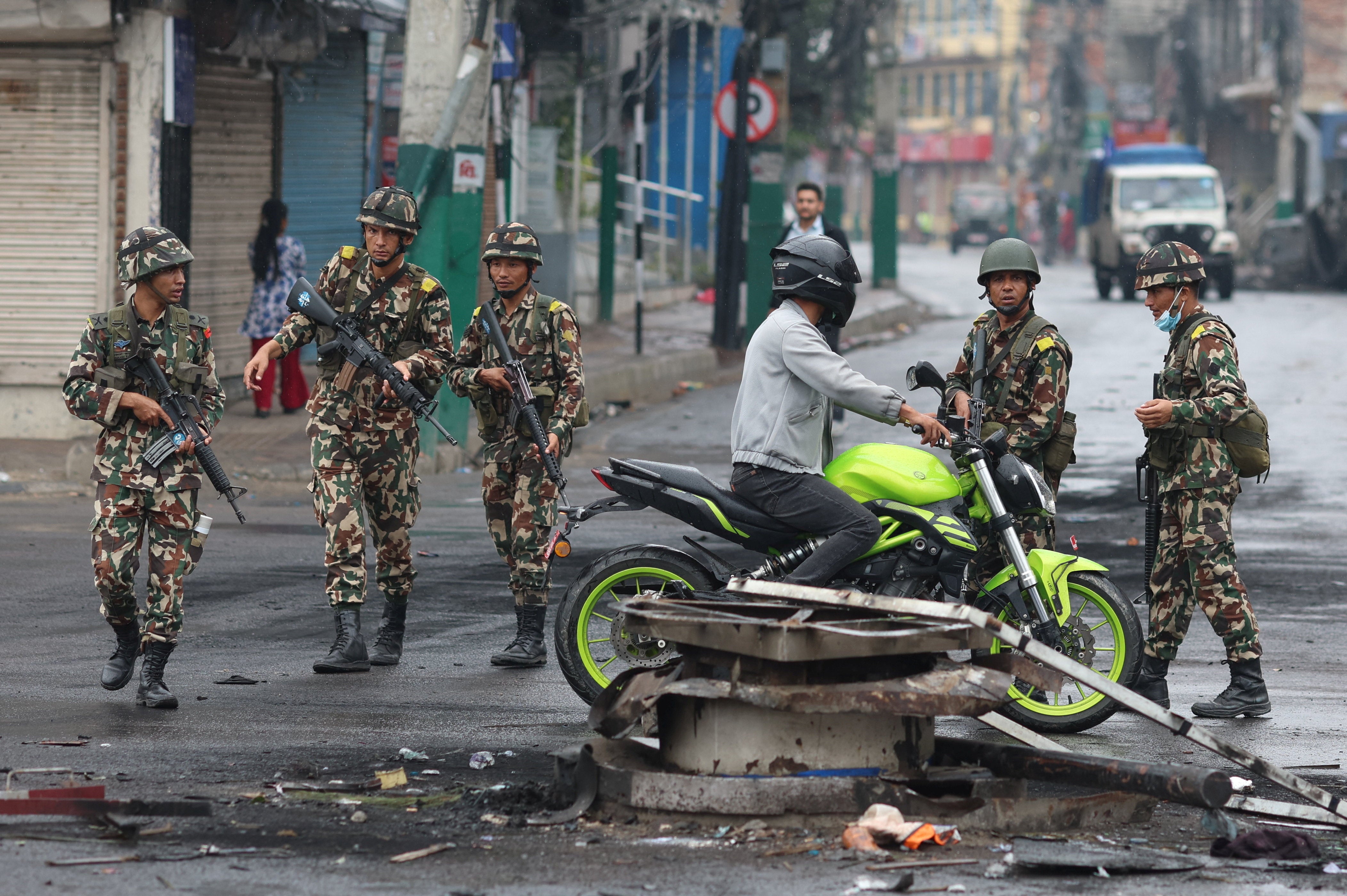 Nepali army soldiers stop a commuter during a curfew outside parliament, following Monday’s killing of 19 people