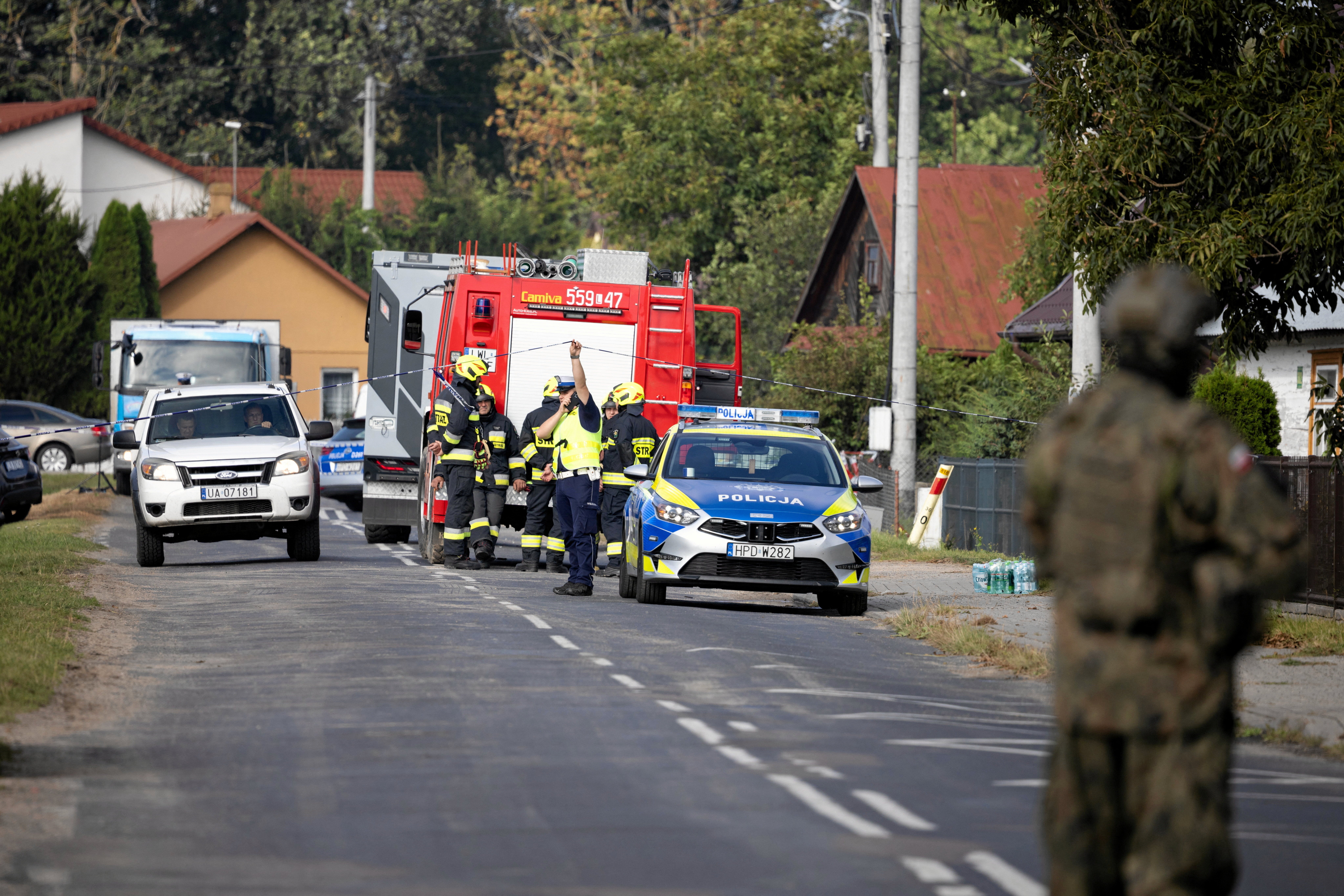 A soldier, firefighters and a police officer stand on the street after a drone or similar object struck a residential building according to local authorities, following violations of Polish airspace during a Russian attack on Ukraine, in Wyryki municipality, Poland September 10, 2025