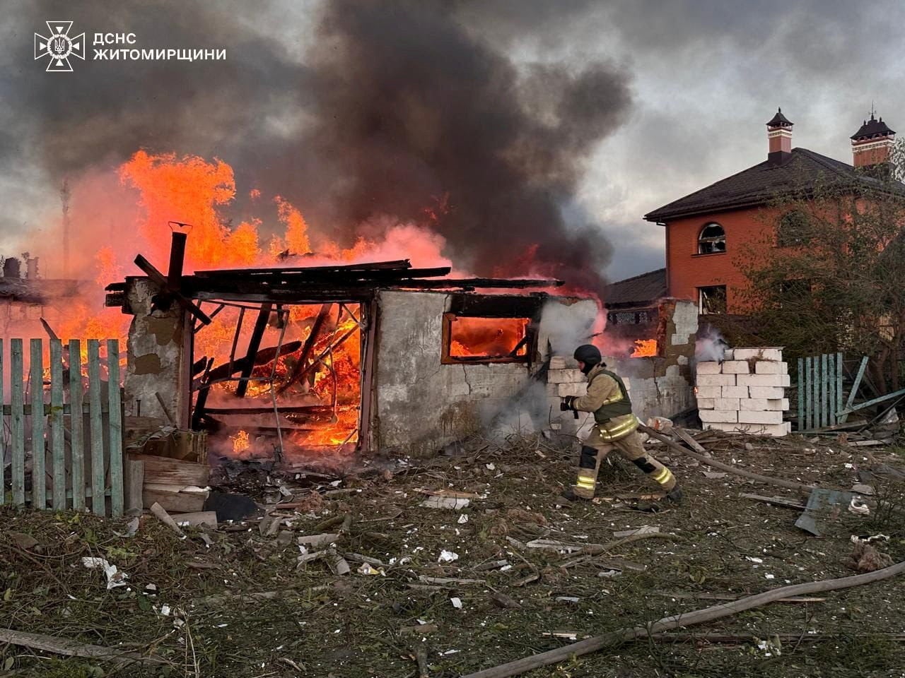 A firefighter runs at the site of a residential area hit during Russian drone and missile strikes in Zhytomyr
