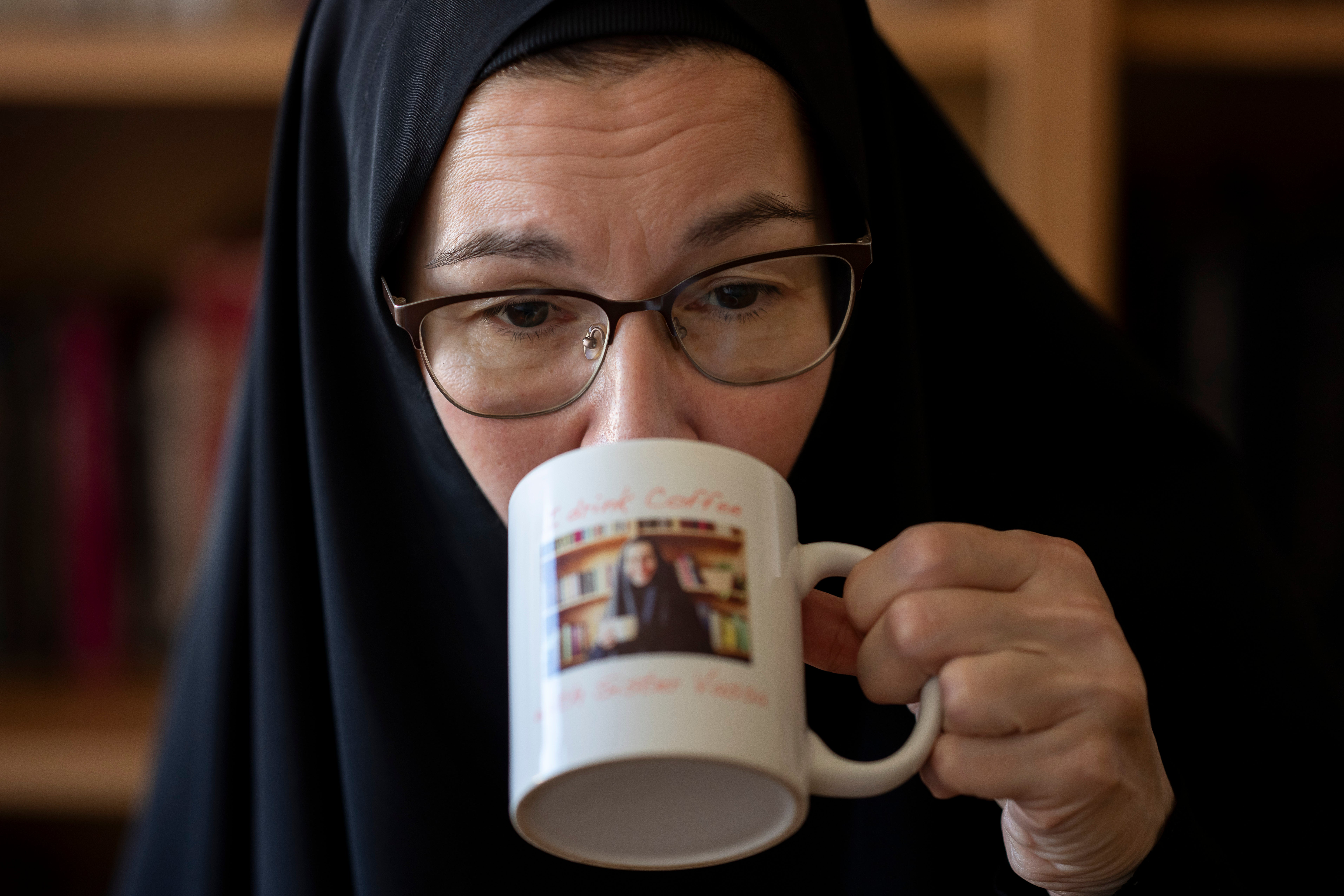 Sister Vassa Larin, a prominent American Orthodox nun, public speaker and YouTube presenter, drinks from a coffee mug during recording one of her videos in Vienna, Austria, on Wednesday, Sept 3. 2025. (AP Photo/Denes Erdos)