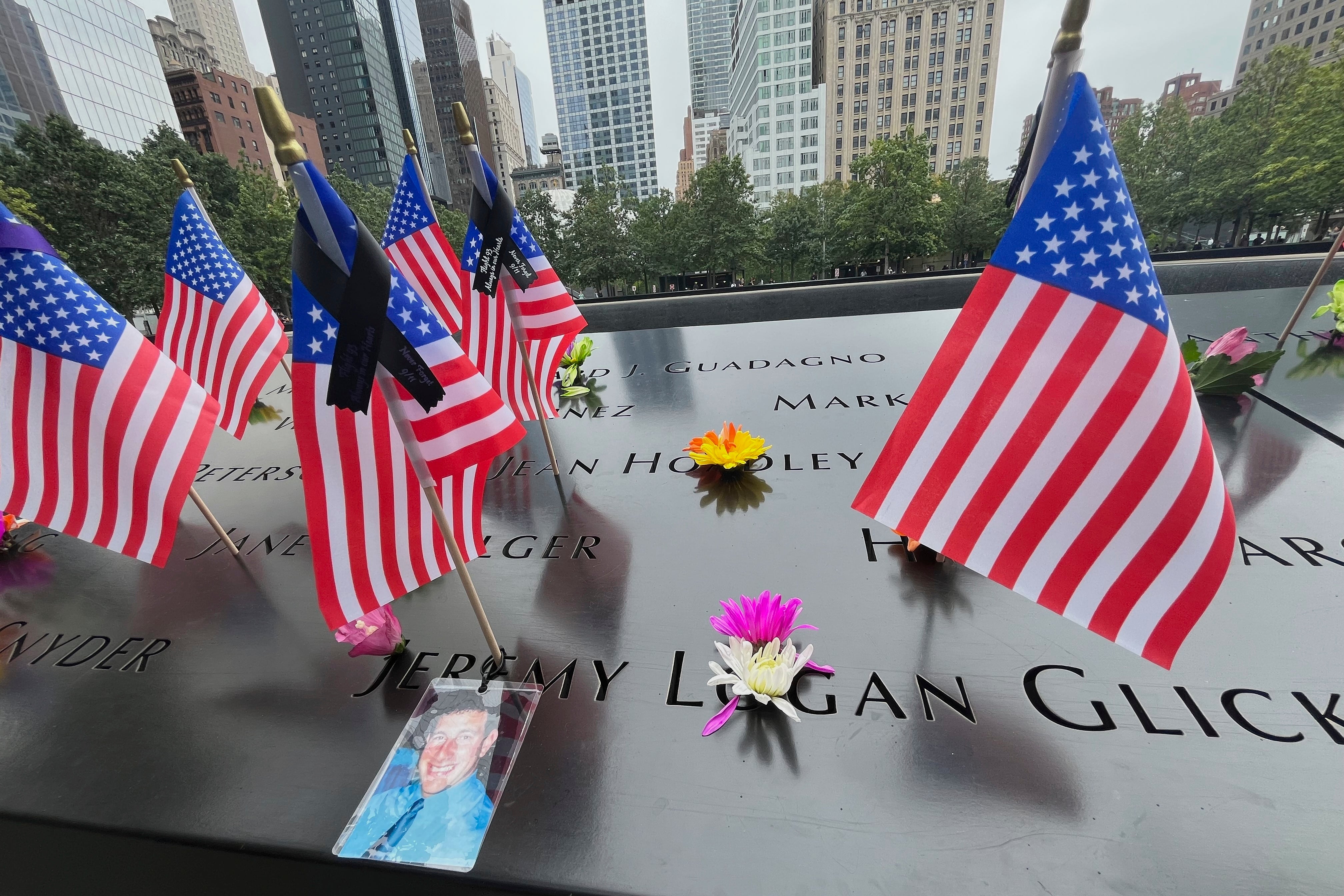 Flags and flowers are placed in the inscribed names at the National September 11 Memorial in New York