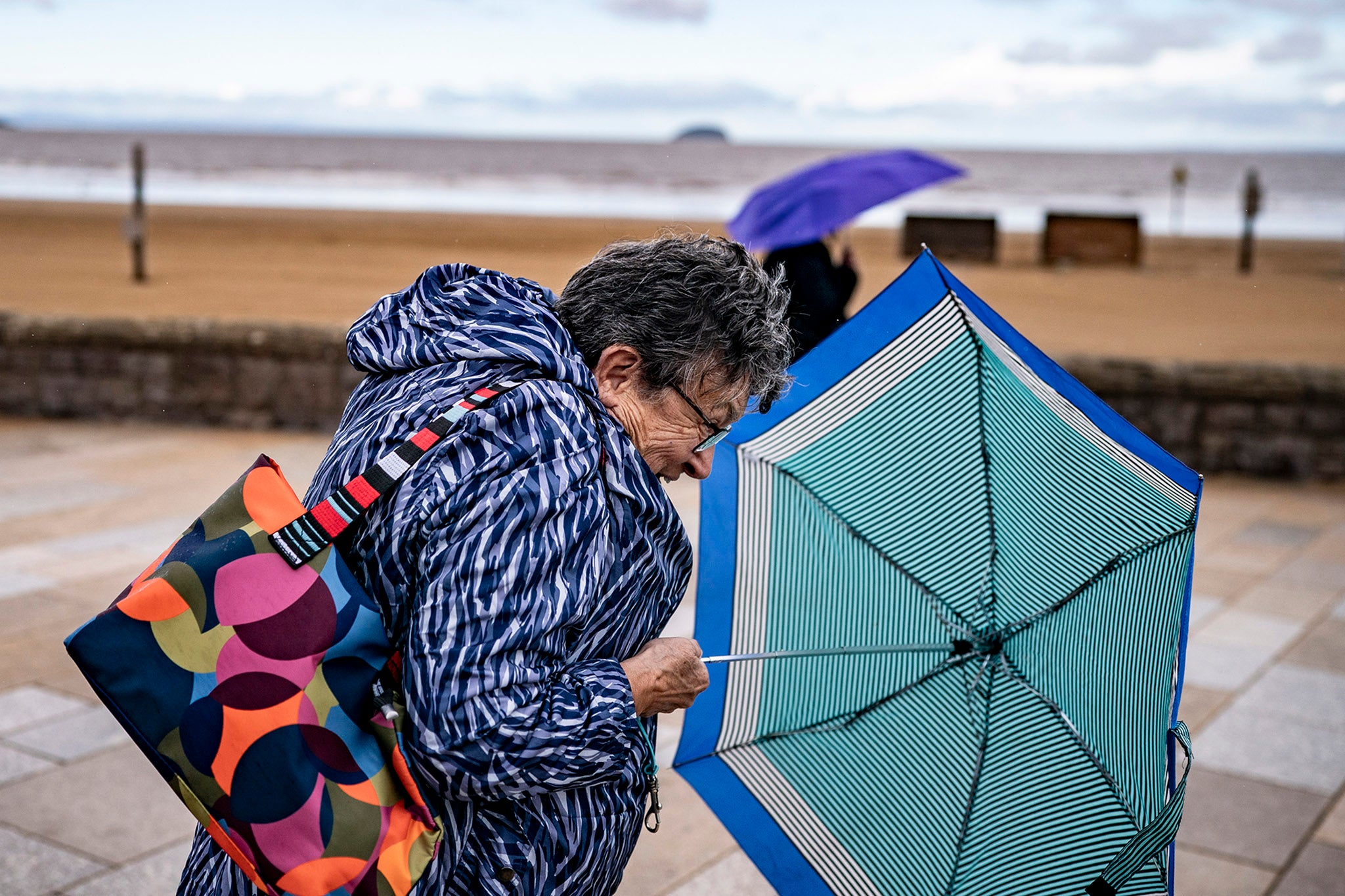 Umbrellas come out on the promenade at Weston-super-Mare, Somerset