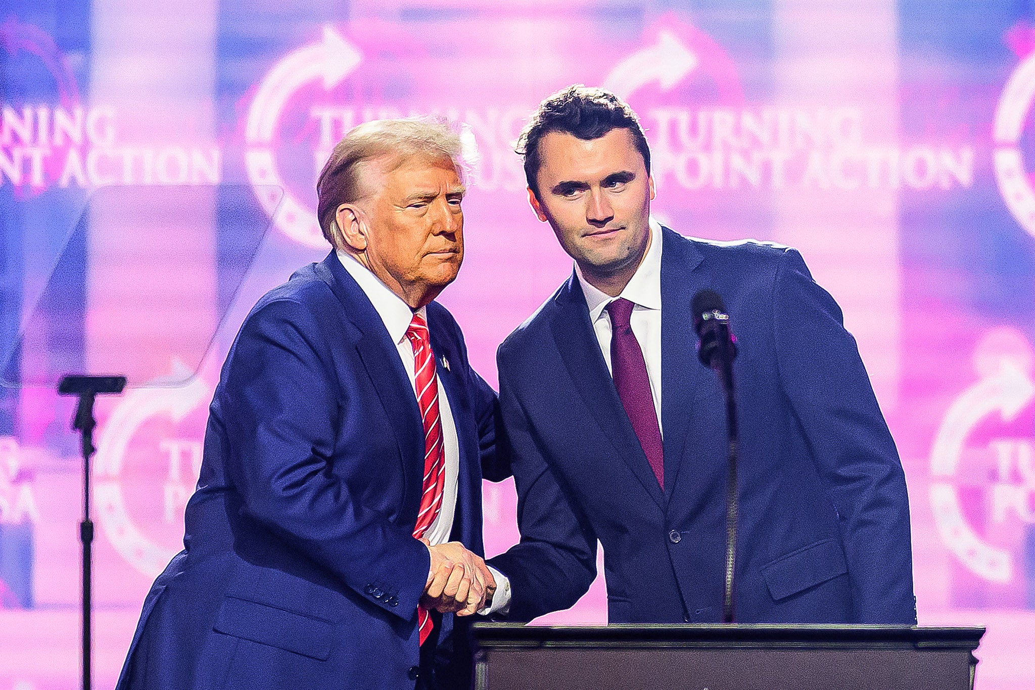 Right-wing activist Charlie Kirk (R) speaks on stage with President Donald Trump at America Fest 2024 in Phoenix, Arizona