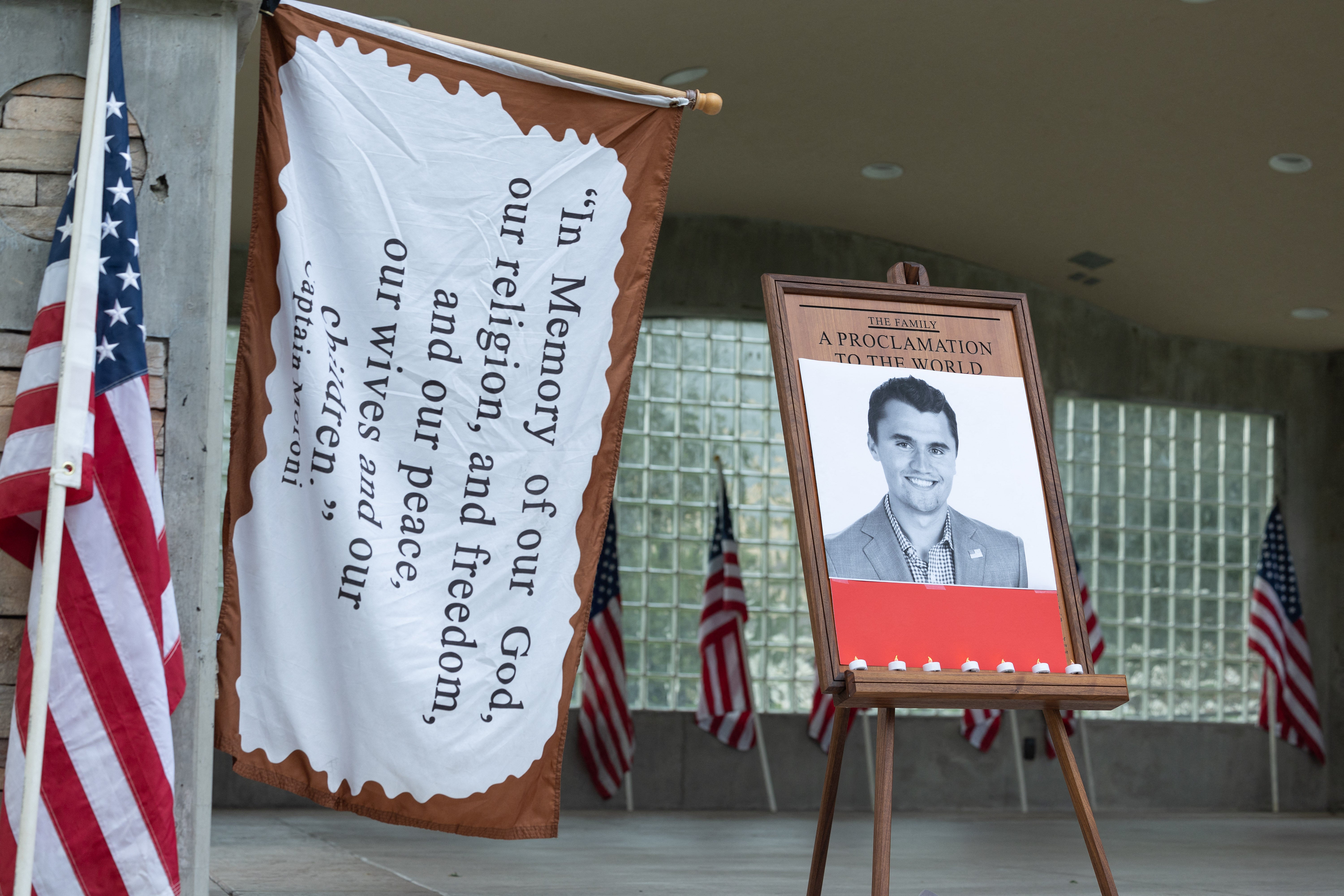 Candles are left in front of a photo of youth activist and influencer Charlie Kirk as people attend a vigil in Orem City Center Park, Orem, Utah