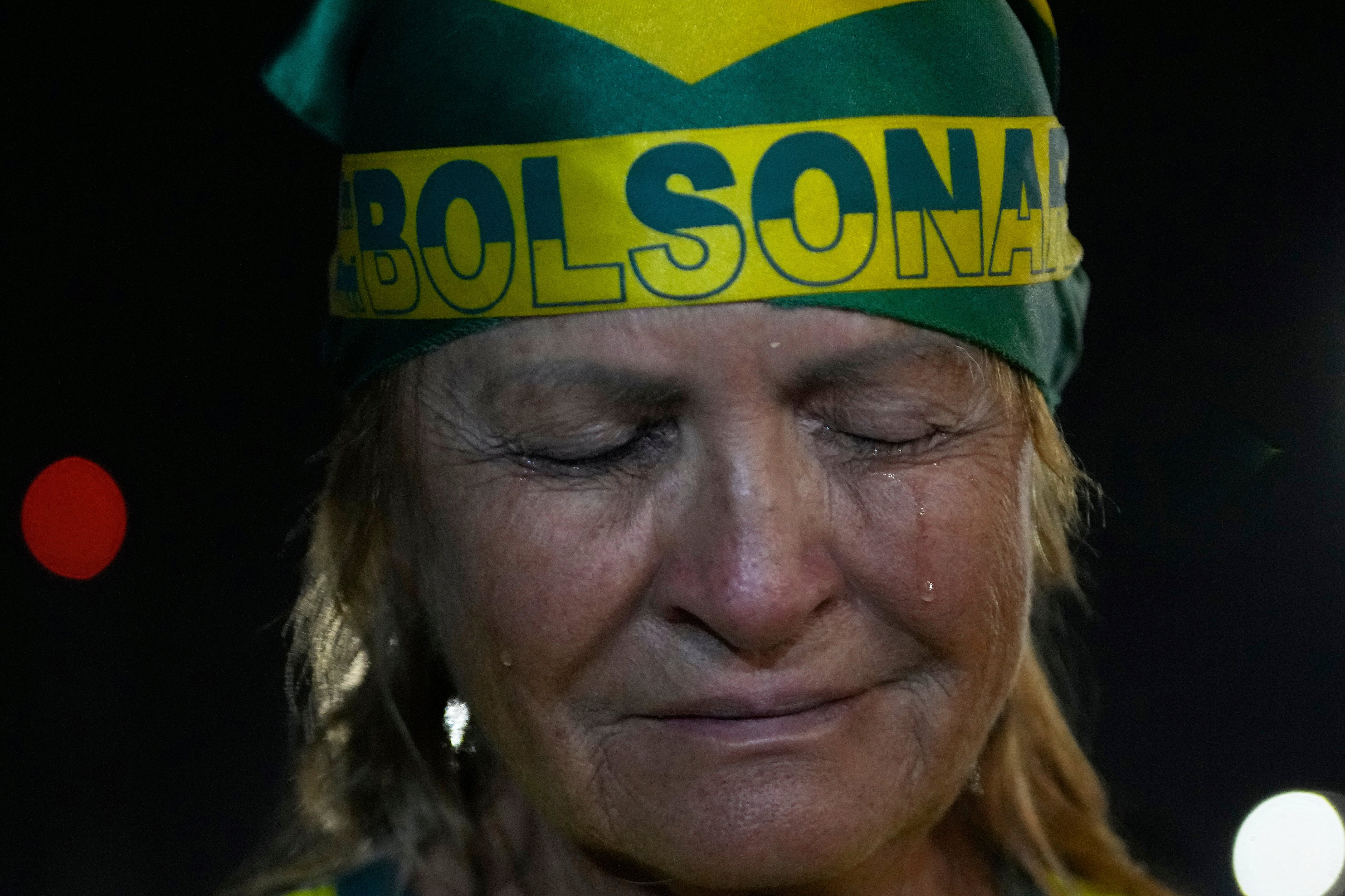 A supporter of former President Jair Bolsonaro cries during a vigil in his support near his home where he is under house arrest in Brasilia, Brazil, Thursday, Sept. 11, 2025. (AP Photo/Eraldo Peres)
