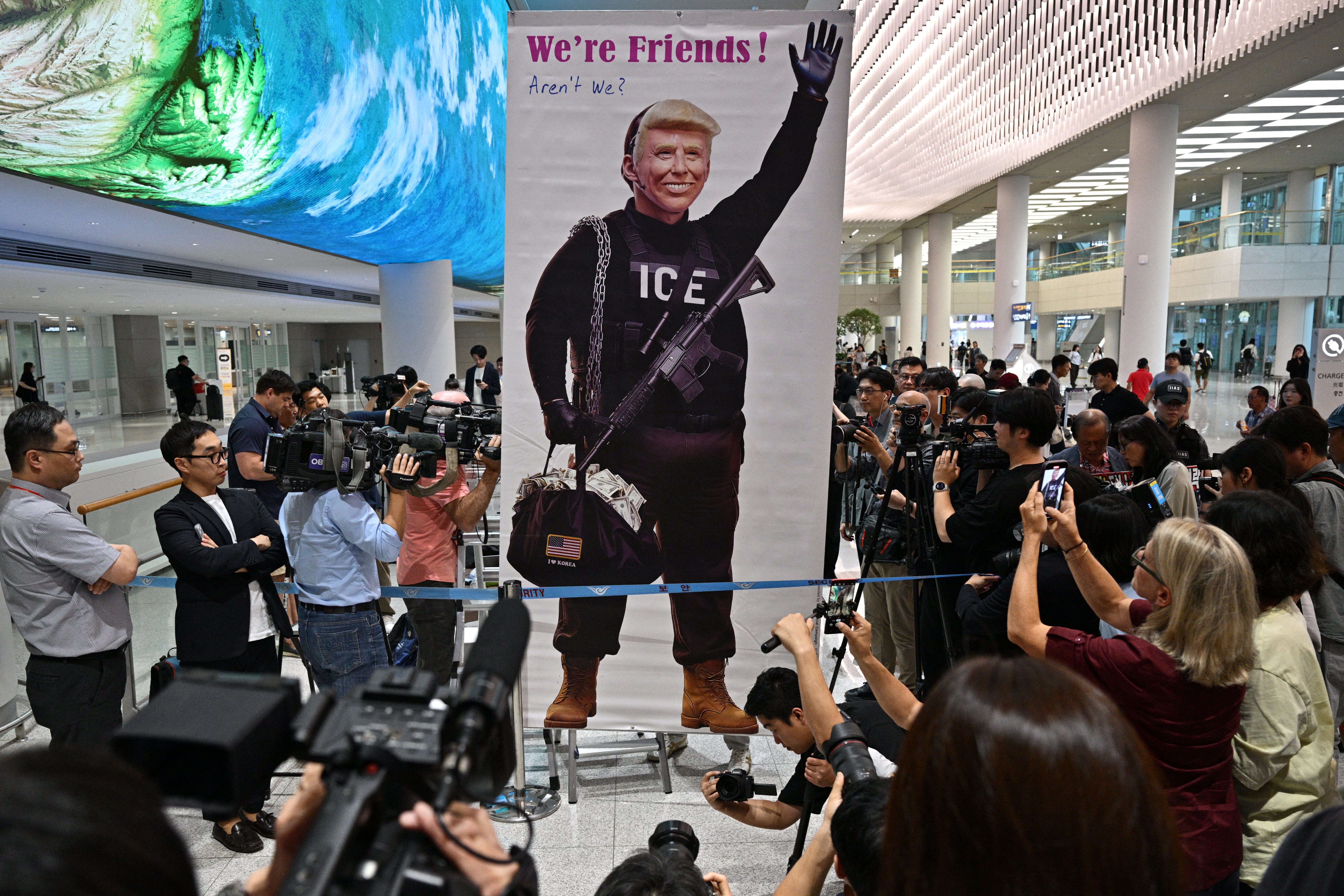 A banner showing US president Donald Trump as an immigration agent is displayed at the Incheon airport on 12 September 2025