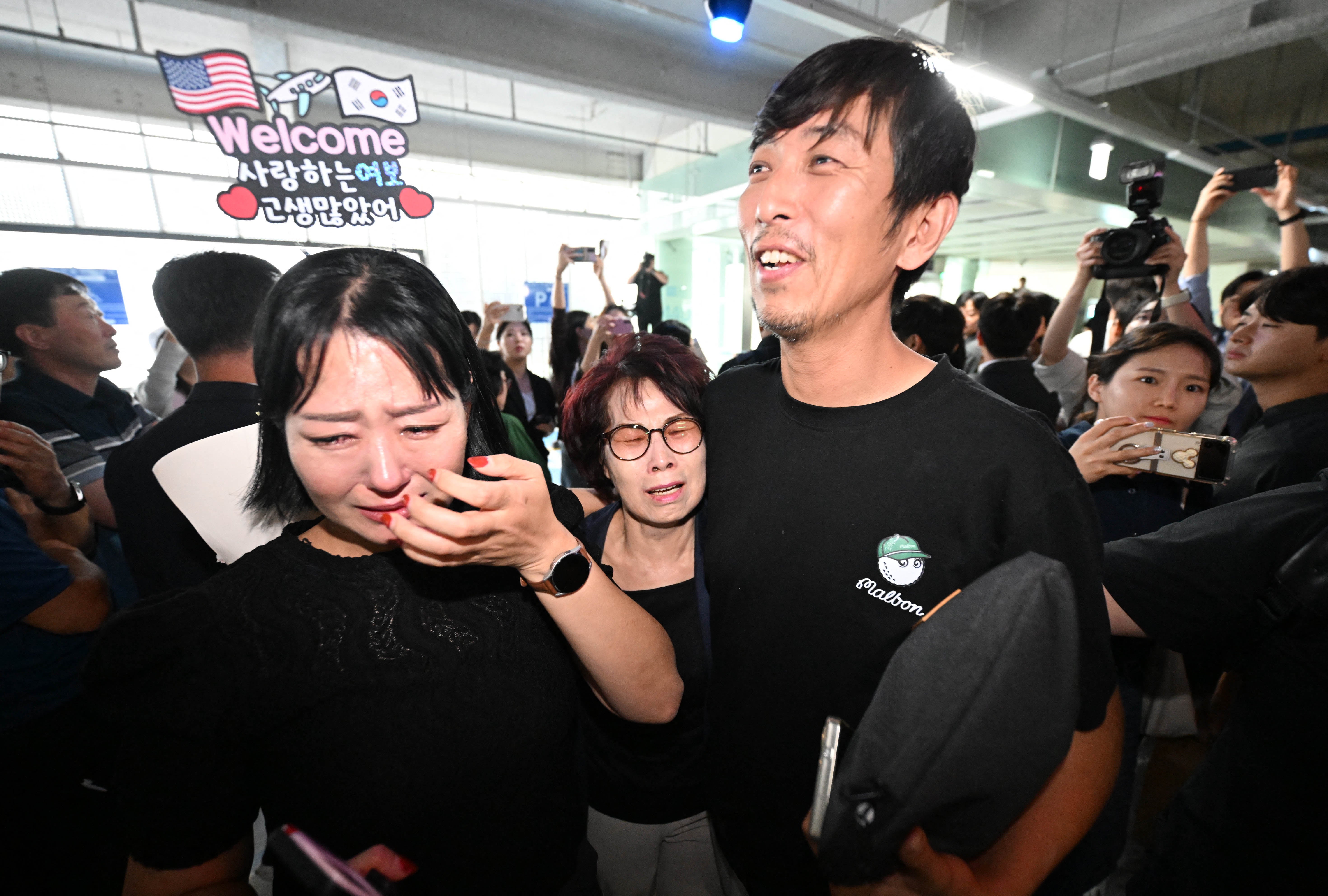 A South Korean worker is welcomed by family members after returning from Atlanta at a parking lot in Incheon International Airport