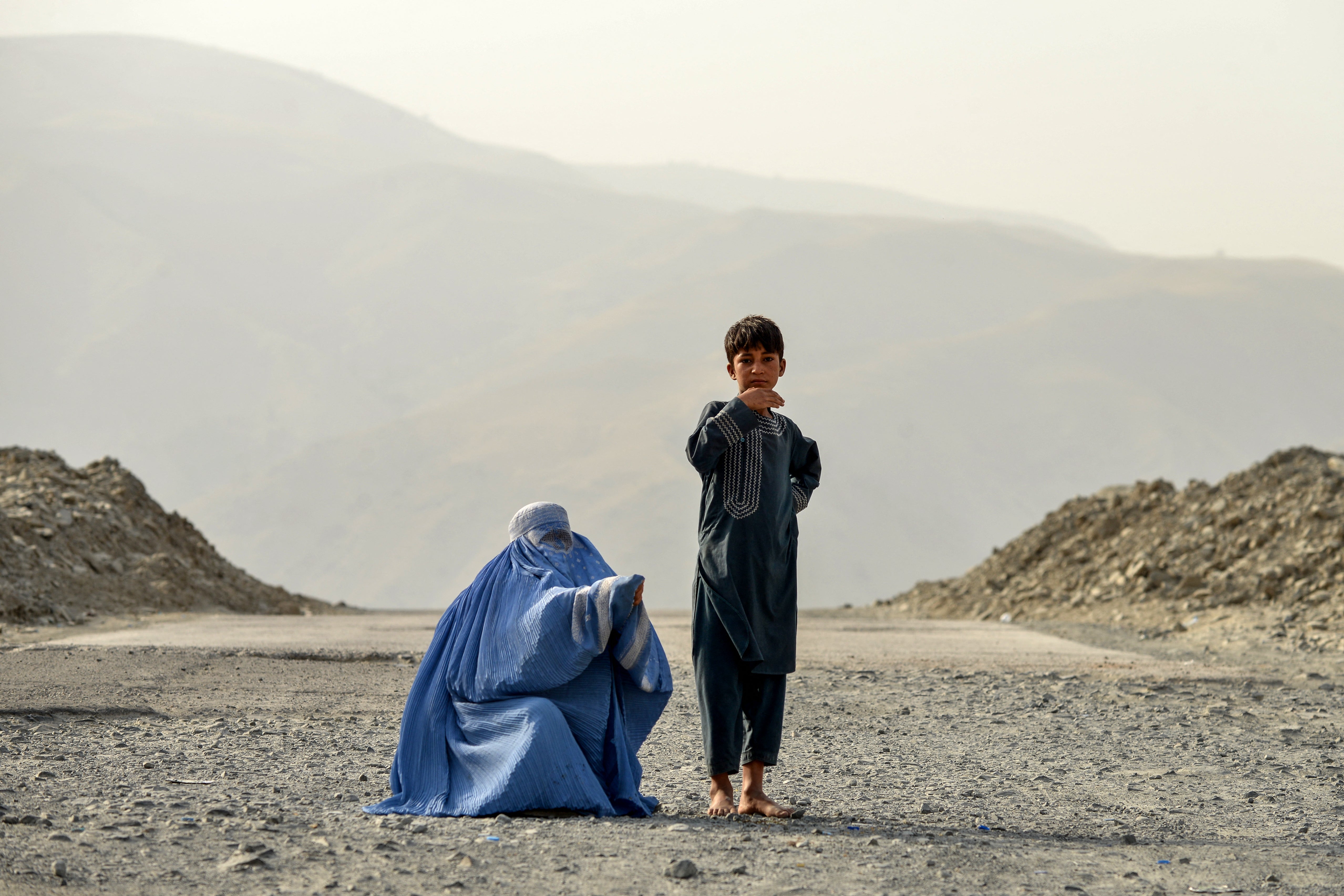 An Afghan woman and a boy seek alms on the outskirts of Faizabad in Badakhshan province