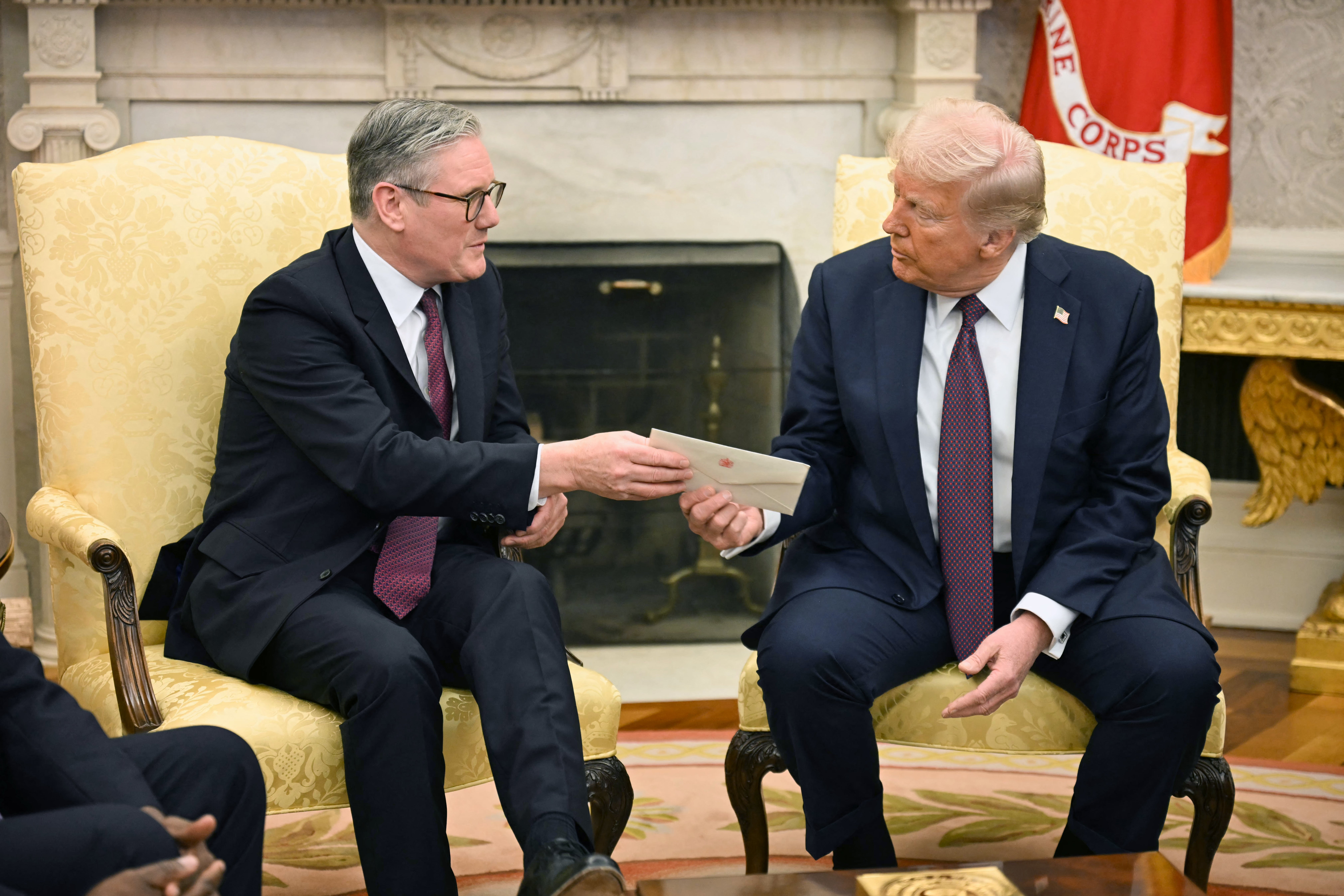 Keir Starmer hands Donald Trump a letter from King Charles III during a meeting in the Oval Office in February
