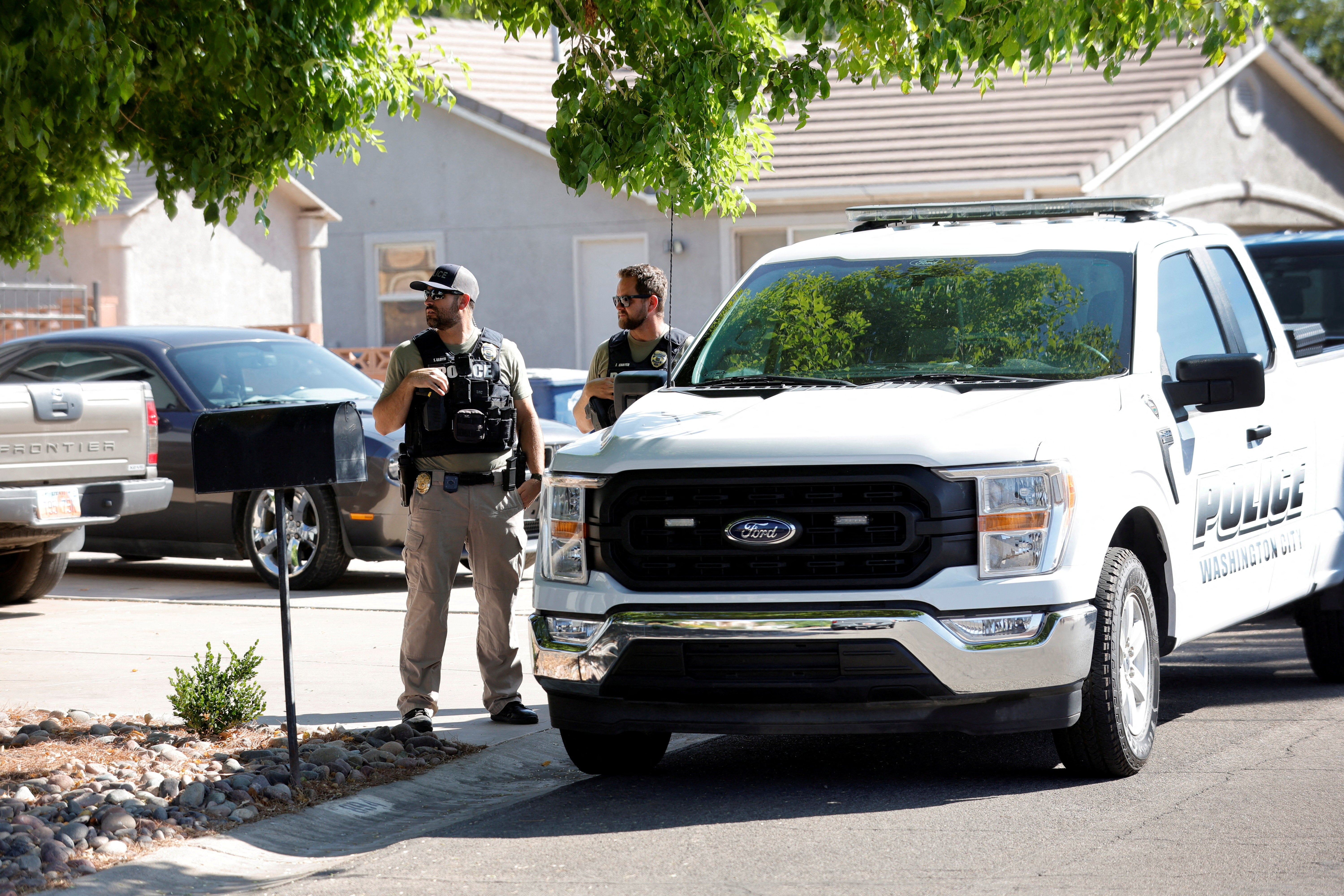 Police stand outside a residence in Washington, Utah, associated with Tyler Robinson