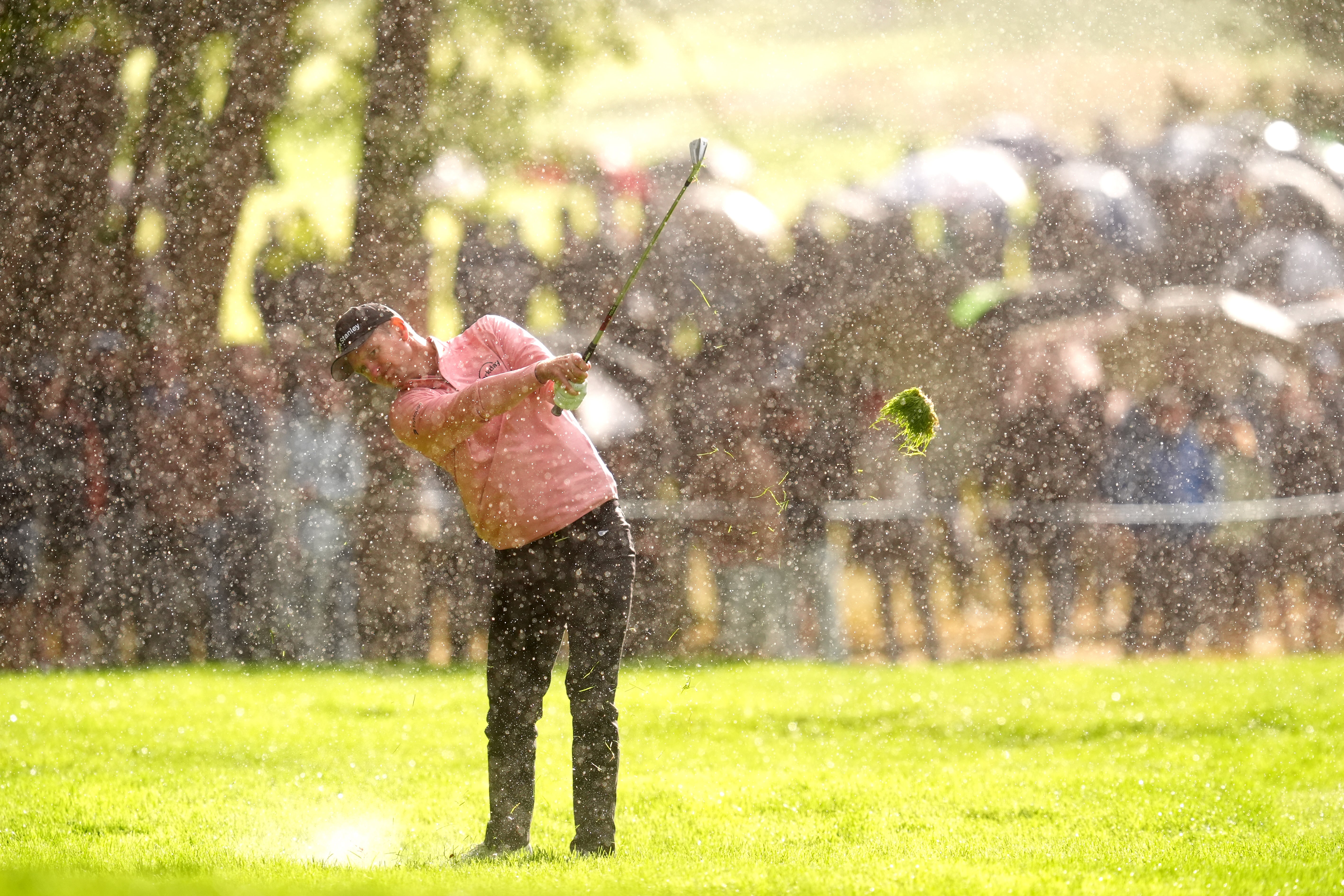 Justin Rose plays from the 17th fairway in heavy rain at the 2025 BMW PGA Championship