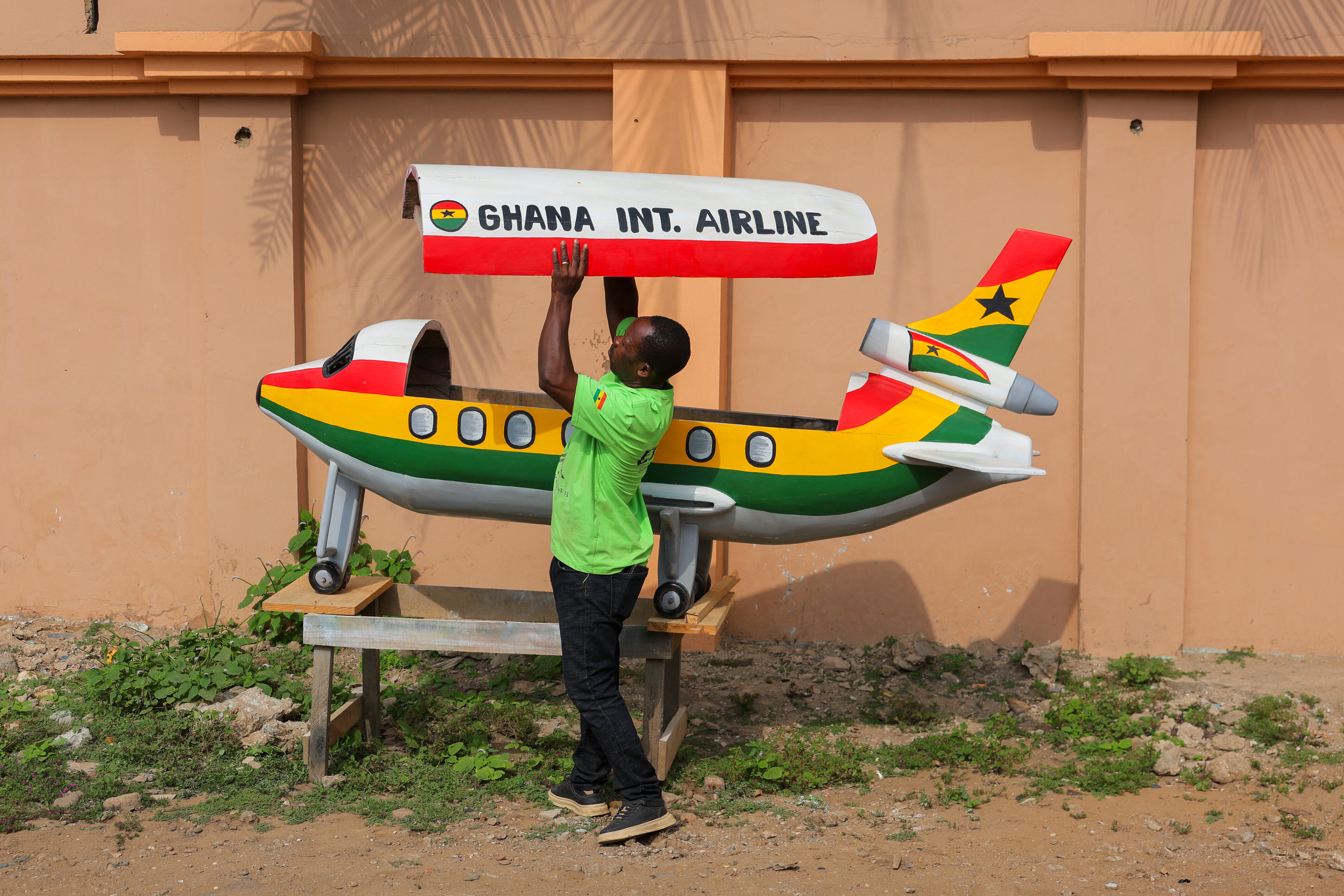Eric Kpakpo Adotey displays an aeroplane fantasy coffin in front of his shop in La, Accra