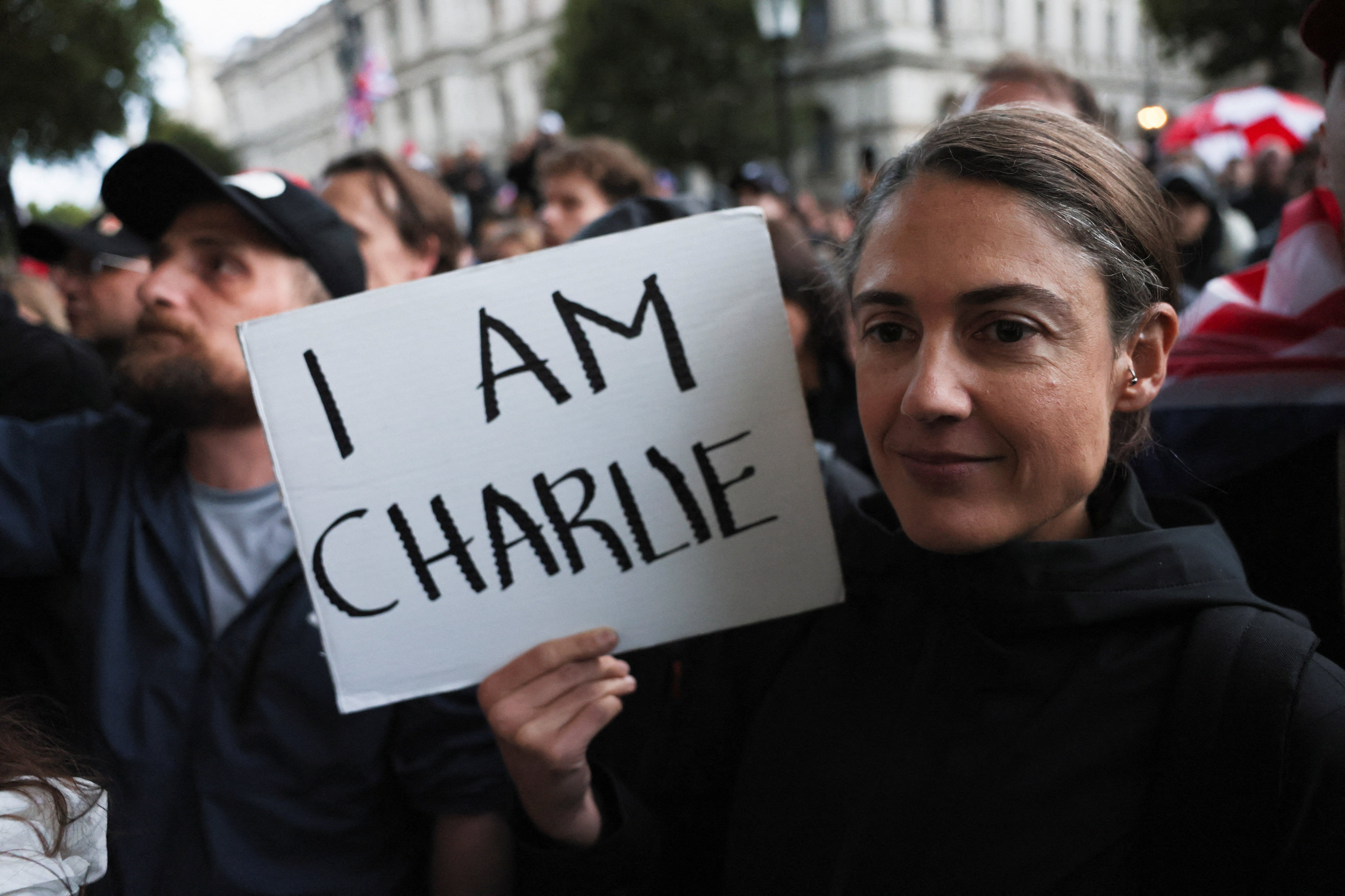 A woman holds a sign reading "I am Charlie" as people attend a vigil for Charlie Kirk in London