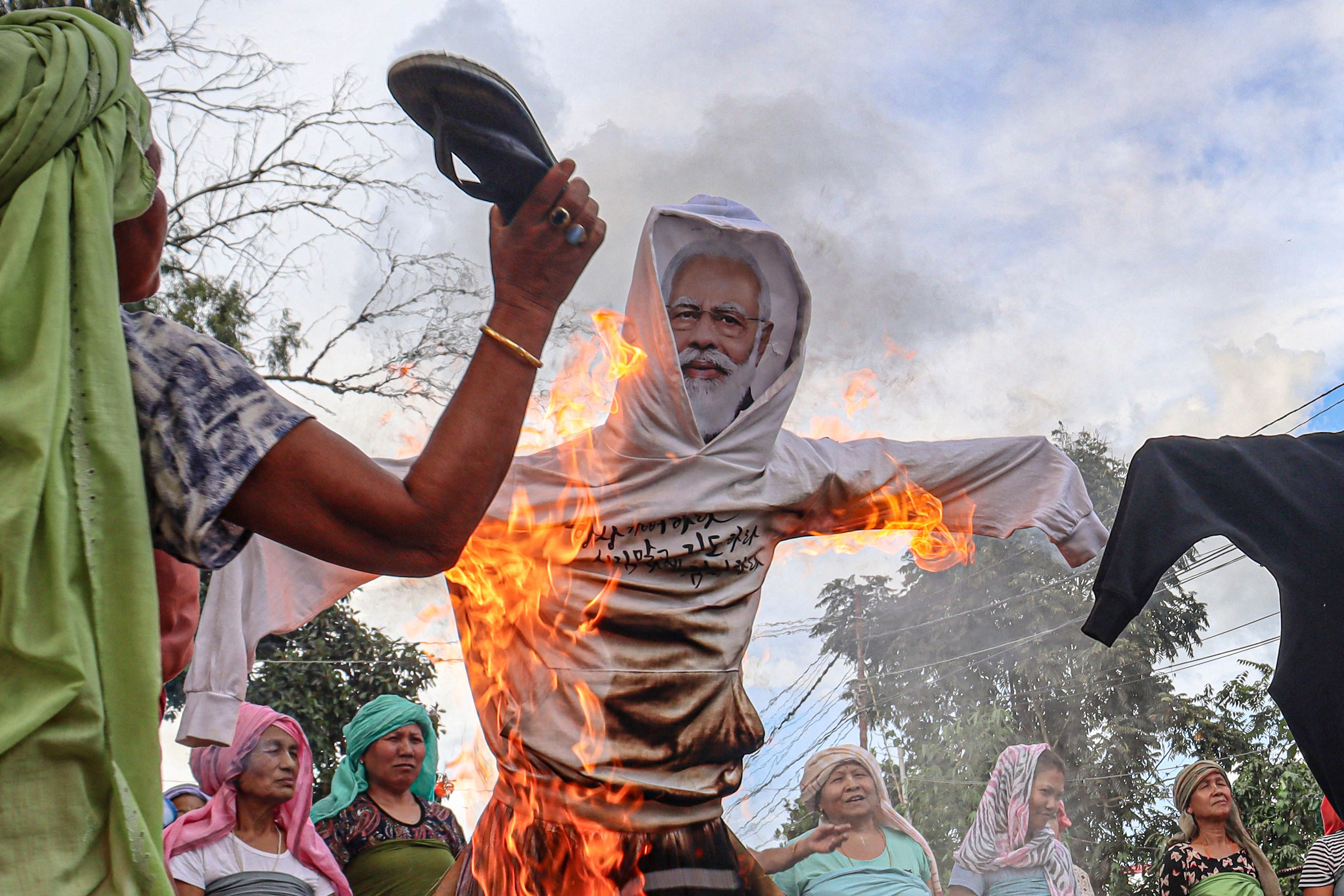 Protesters burn an effigy of Prime Minister Narendra Modi during a demonstration in Imphal