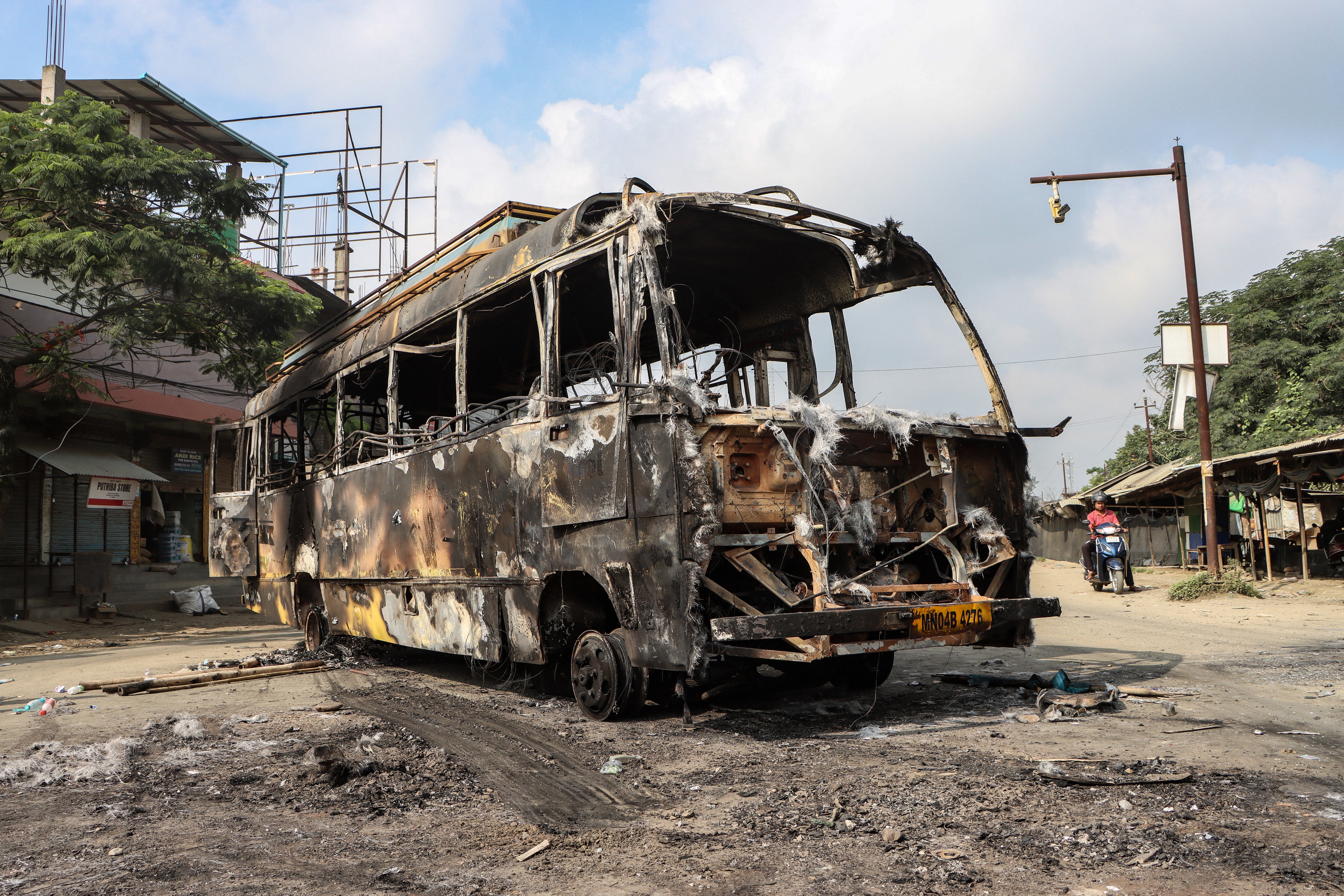 The wreckage of a burned-out bus is pictured along a street after a recent violence in Imphal in the Indian state of Manipur